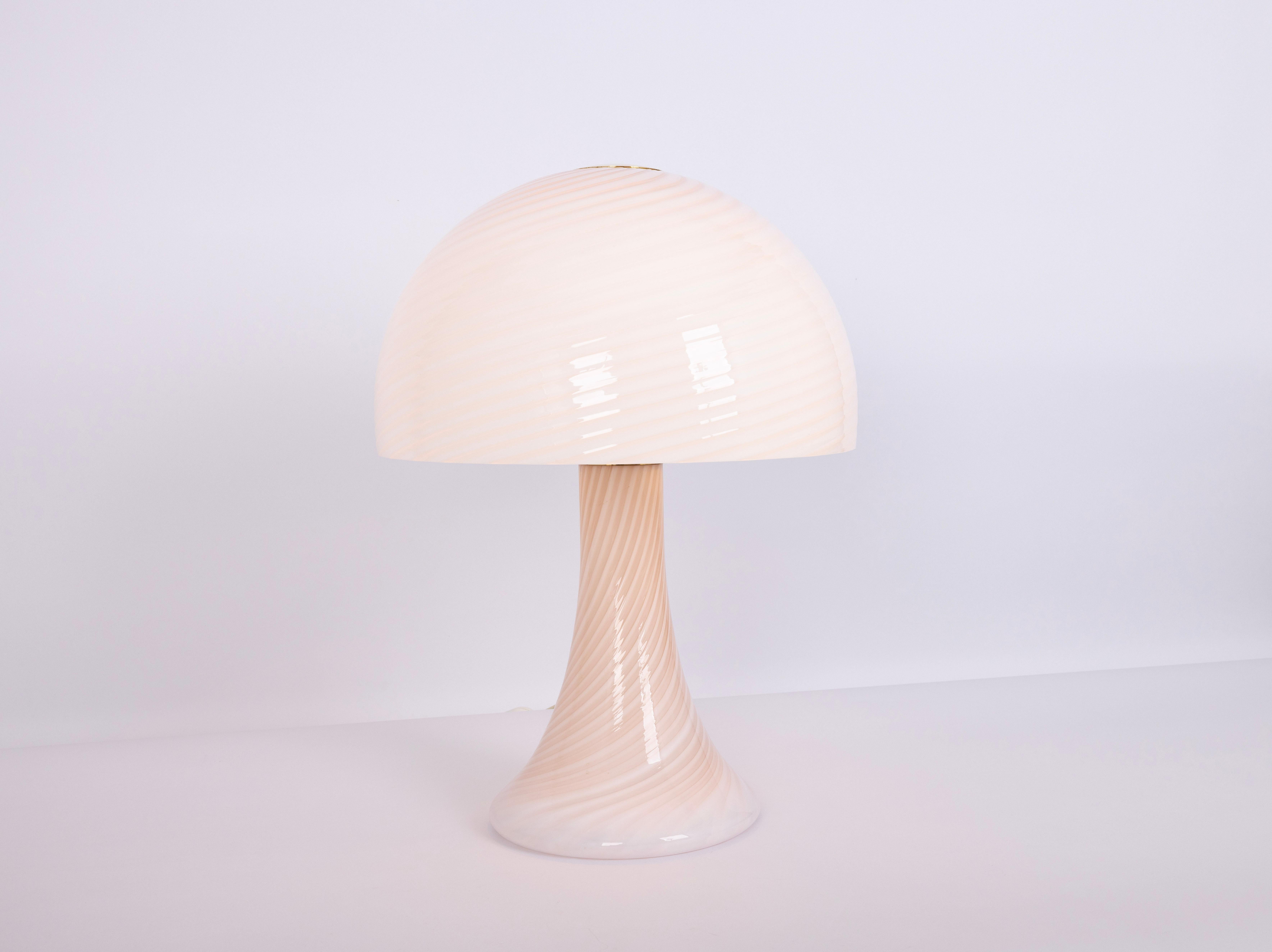 Murano Table Lamp by J.T. Kalmar from the 1980s
Beautiful vintage Murano glass table lamp designed by J.T. Kalmar in the 1980s. The lamp features a mushroom shape with hand-blown glass in a soft peach tone and white swirl pattern. When lit, it