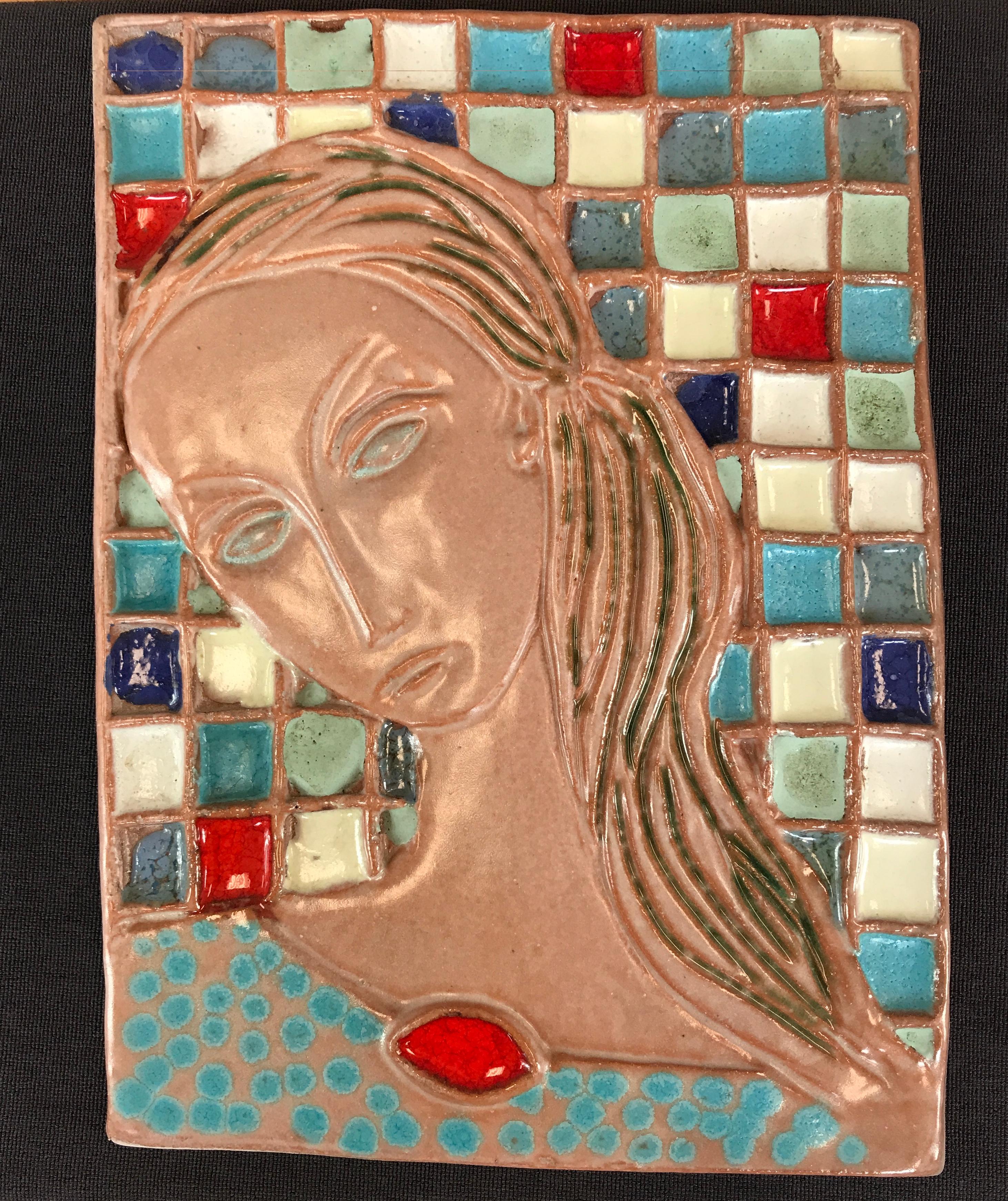 A large Harris Strong tile art, with the subject being of a woman with long hair. The back ground could remind you of a tiled wall, with the squares being many different colors.
The tile is not labeled or signed.