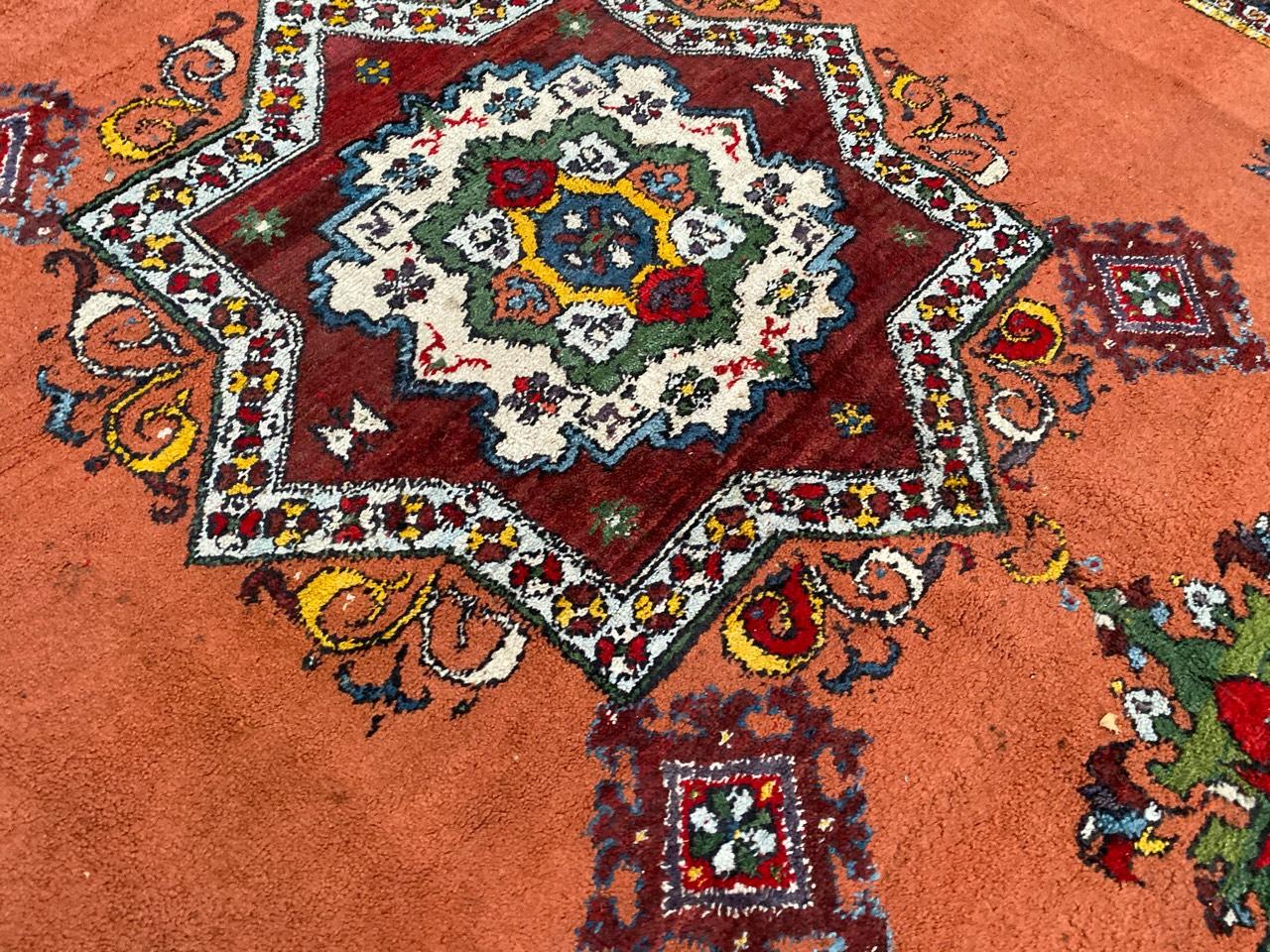 Très beau tapis marocain avec un joli motif tribal avec un médaillon central, et de belles couleurs avec de l'orange, du rouge, du bleu, du jaune, du vert et du violet, entièrement noué à la main avec du velours de laine sur une base de laine.