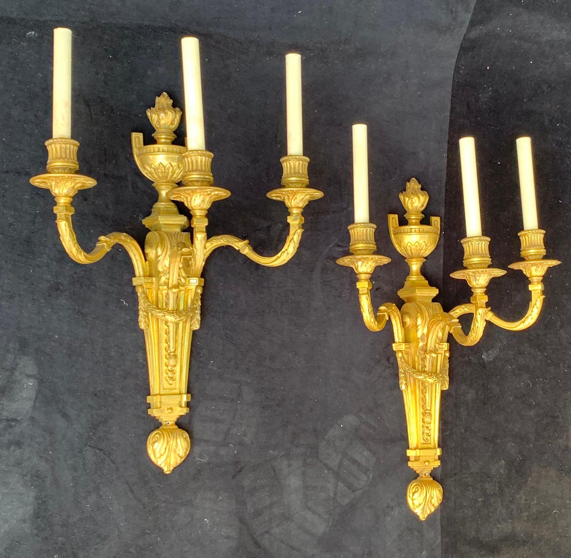 A wonderful large pair of French style urn top garland swag neoclassical bronze E.F. Caldwell stamped sconces each with 3 candelabra lights, rewired and ready to enjoy.