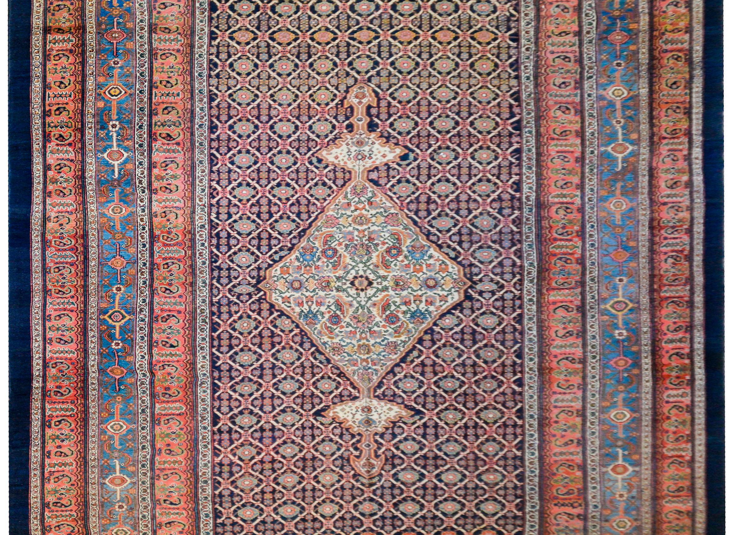 A wonderful late 19th century Persian Bibikibad rug with a fantastic large central diamond medallion with a multicolored floral and vine pattern, on top of an all-over trellis of stylized flowers and vines on a dark indigo background. The border is