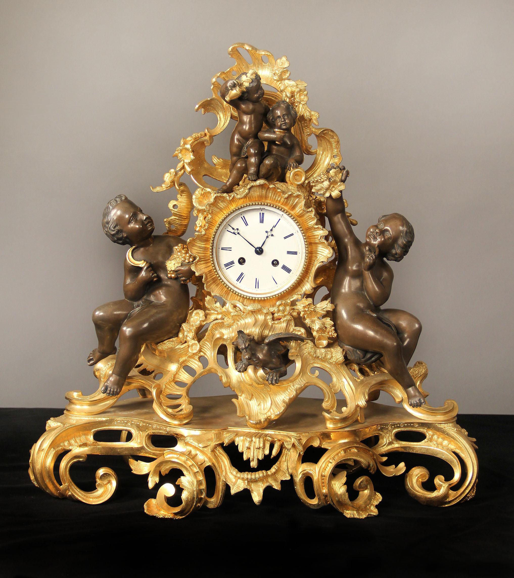 A wonderful late 19th century gilt and patinated bronze three-piece clock set.

The large Rococo style figural clock surrounded by large and small putti, the bottom with a dragon. Each of the candelabra with sitting putti holding seven lights,