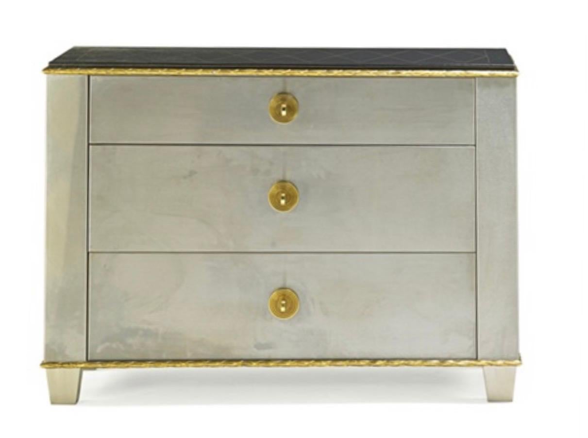 A wonderful Lorin Marsh three-drawer chest in stainless steel with hand-tooled leather top, with Russian gold bronze drawer pulls and acanthus leaves detail Called The 