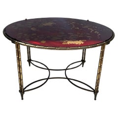 Merveilleuse table basse ronde de la Maison Bagues de style Chinoiserie en laque rouge, bambou et bronze