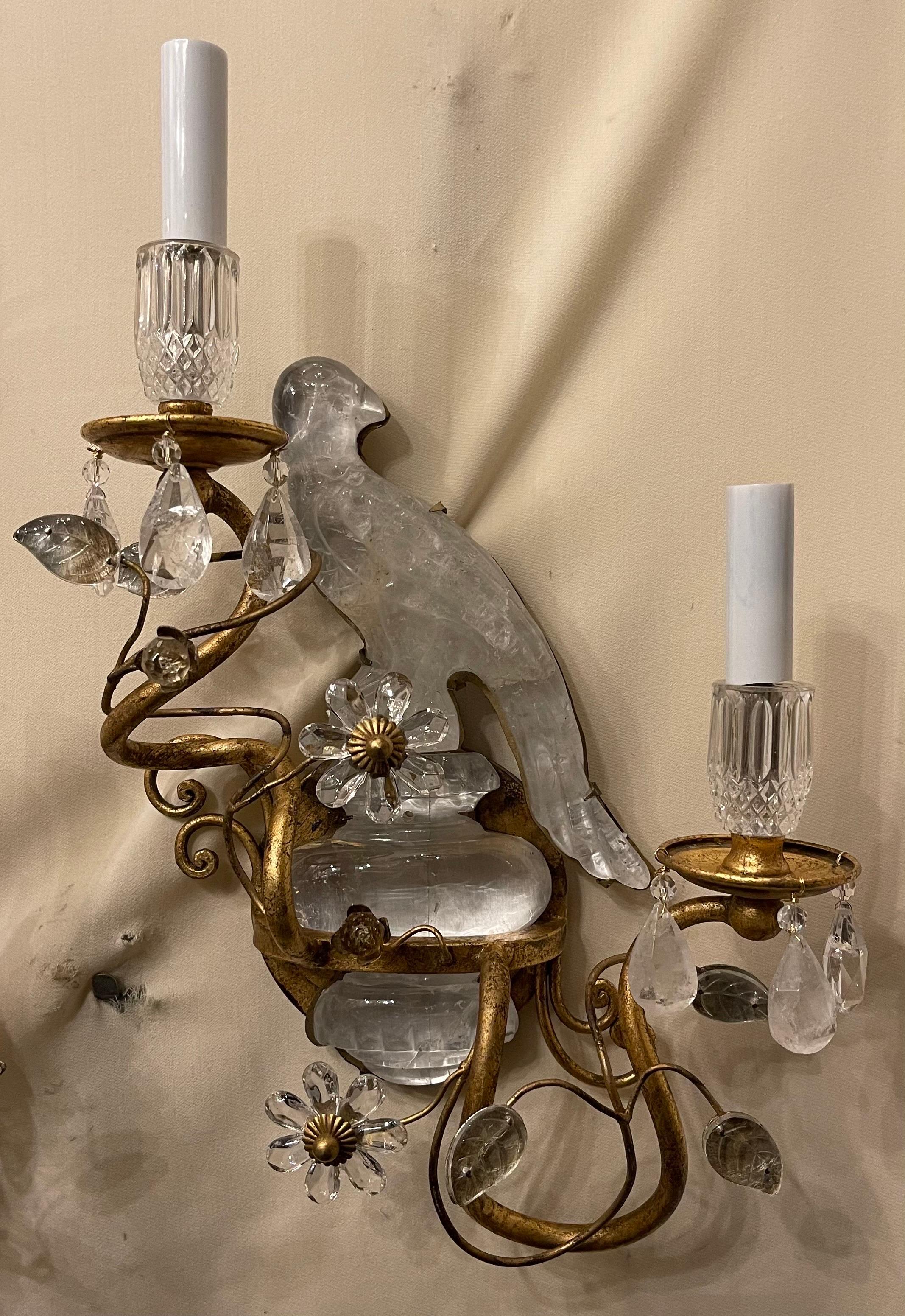 Merveilleuse paire d'appliques de style Maison Baguès à deux chandeliers en cristal de roche avec oiseau/perroquet reposant sur une urne.
Les deux oiseaux en cristal de roche ont été réparés et le câblage a été mis à jour.