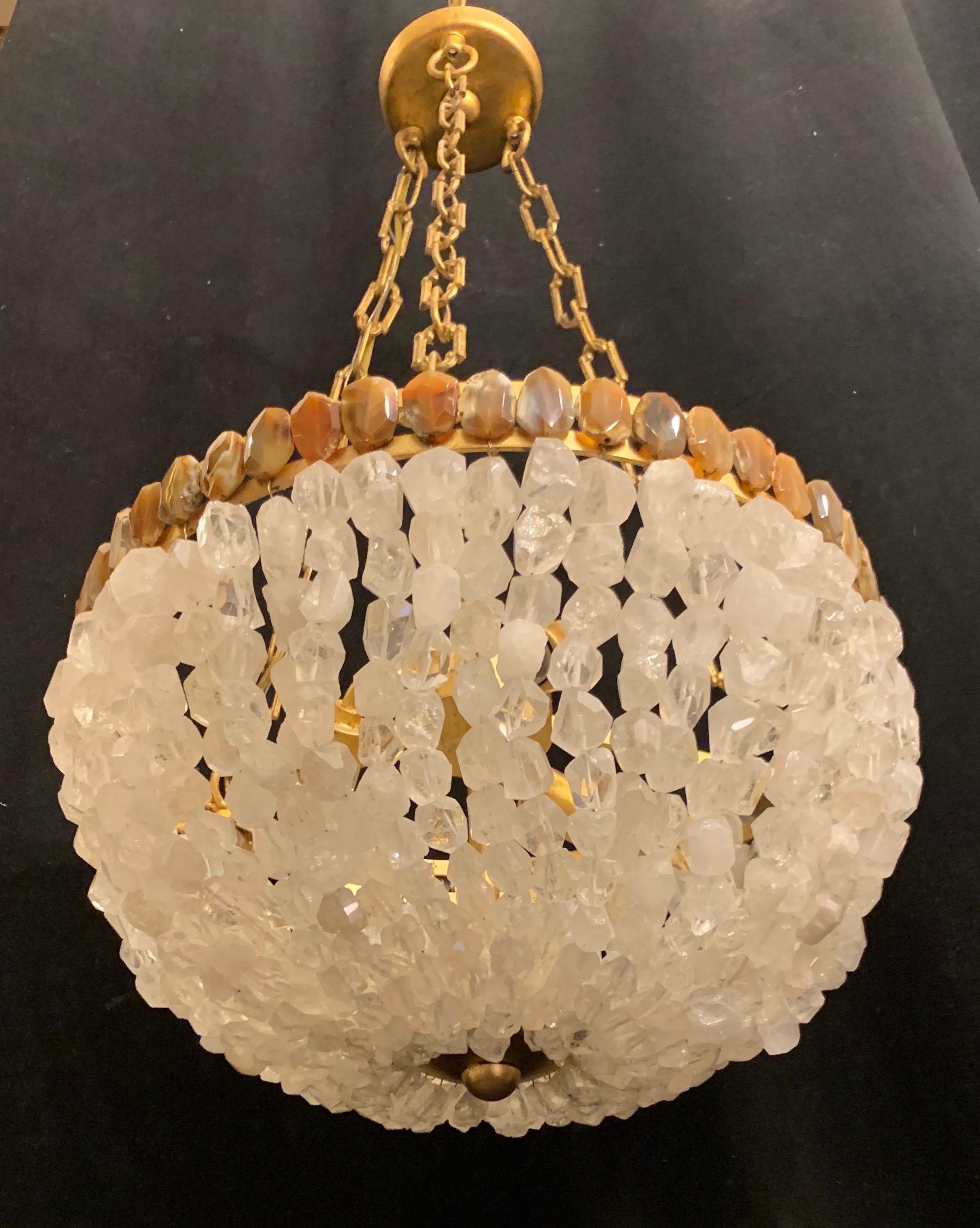 A wonderful large wrought iron gold gilt frame with chain leading to a basket form chandelier dressed with rough-cut clear quartz rock crystal stones and the rim trimmed with natural agate faceted accent stones. The interior with 3 Edison sockets,