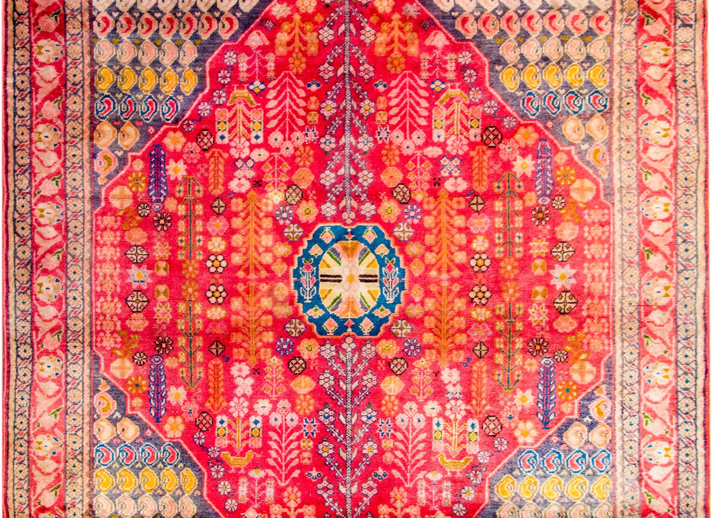 Wonderful mid-20th century Persian Arak rug with a fantastic central diamond medallion woven with myriad trees-of-life on a bright crimsons background. The diamond medallion lives amidst an interesting field os multicolored paisleys, surrounded by a
