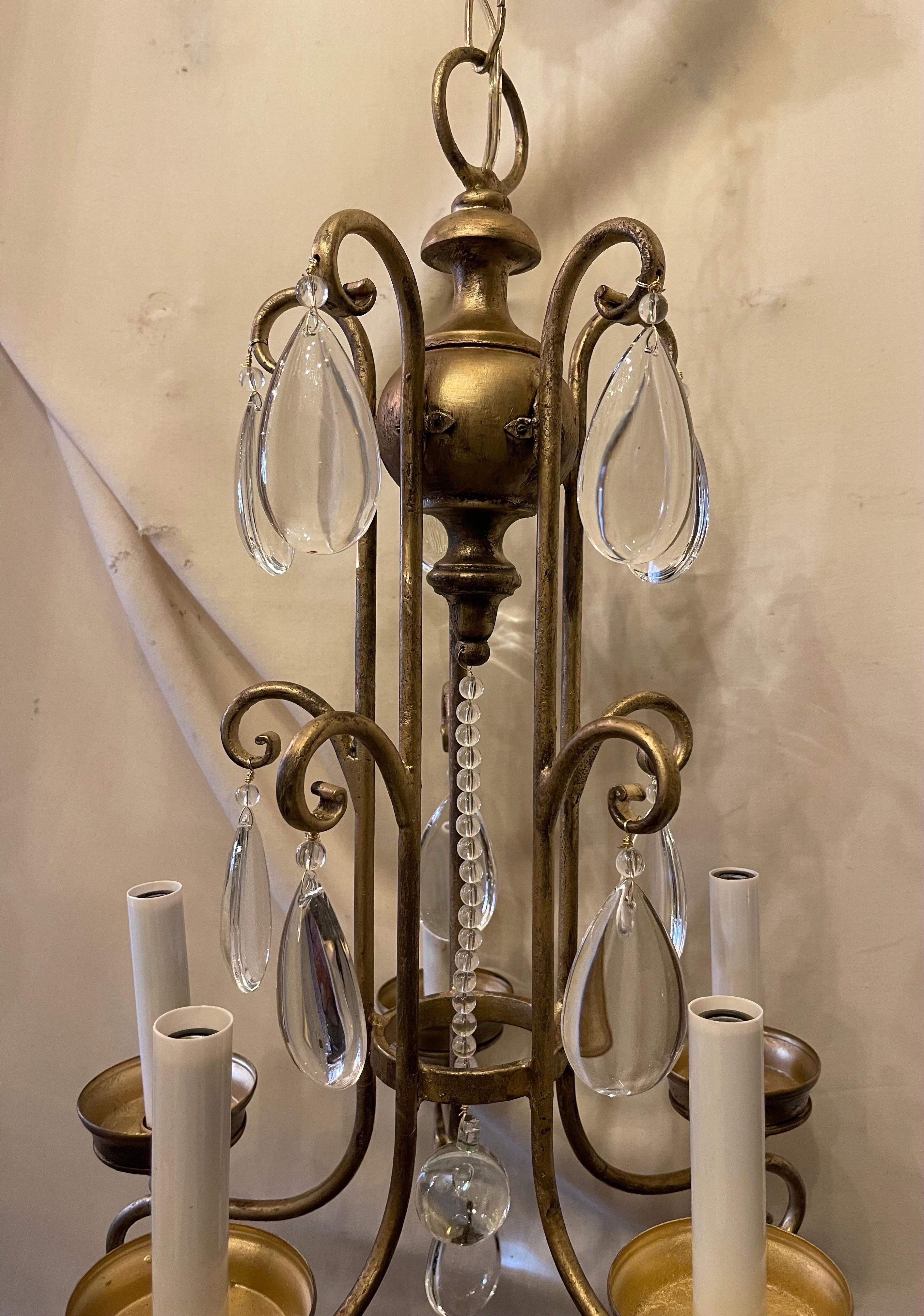 Merveilleux lustre à 5 chandeliers de style Maison Bagues du milieu du siècle dernier, en or doré et cristal. Ce lustre a été recâblé et est accompagné d'une chaîne et d'un baldaquin.