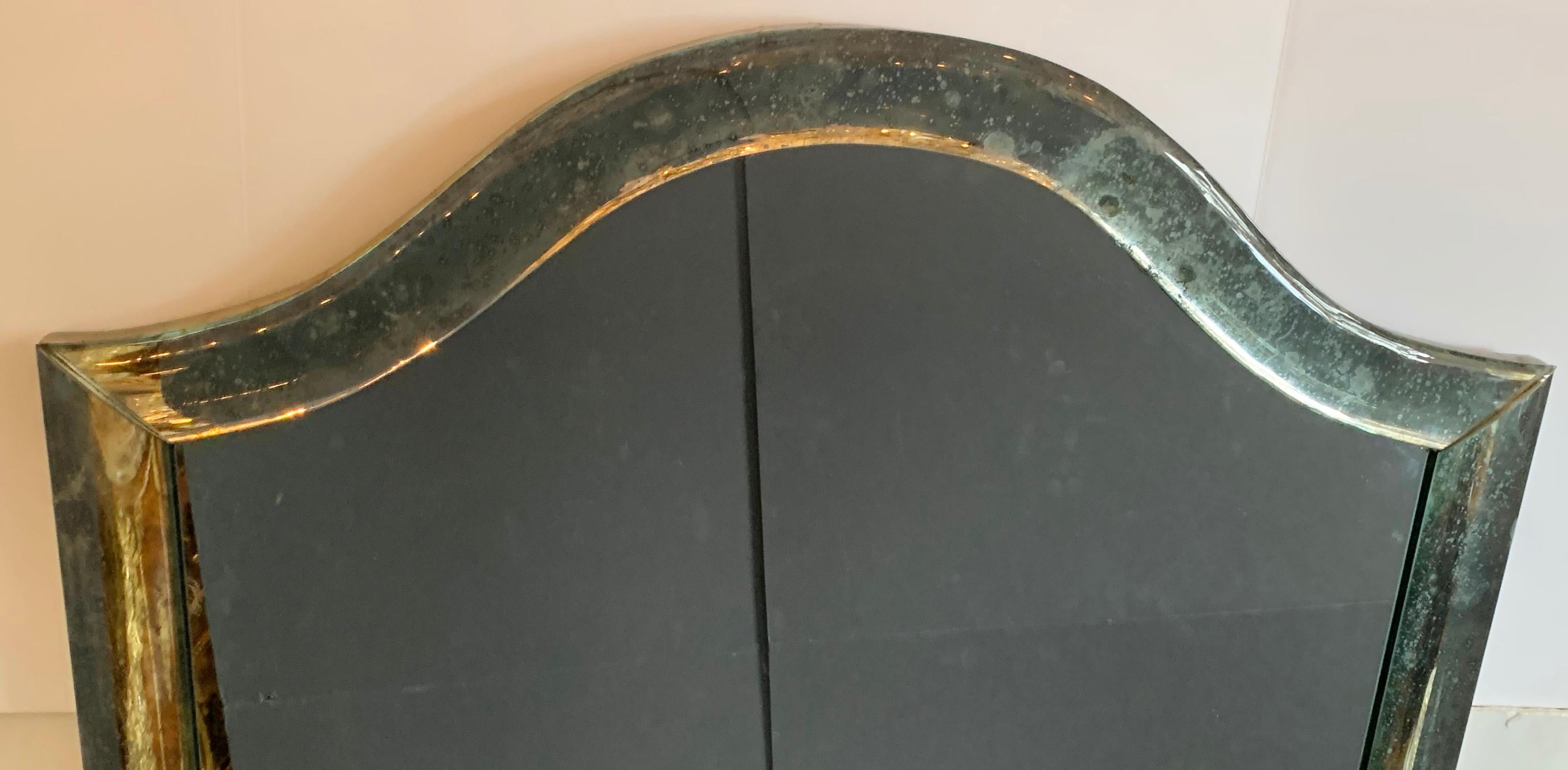 A wonderful Mid-Century Modern Venetian distressed / oxidized / pitted curved panel mirror in the manner of Karl Springer.