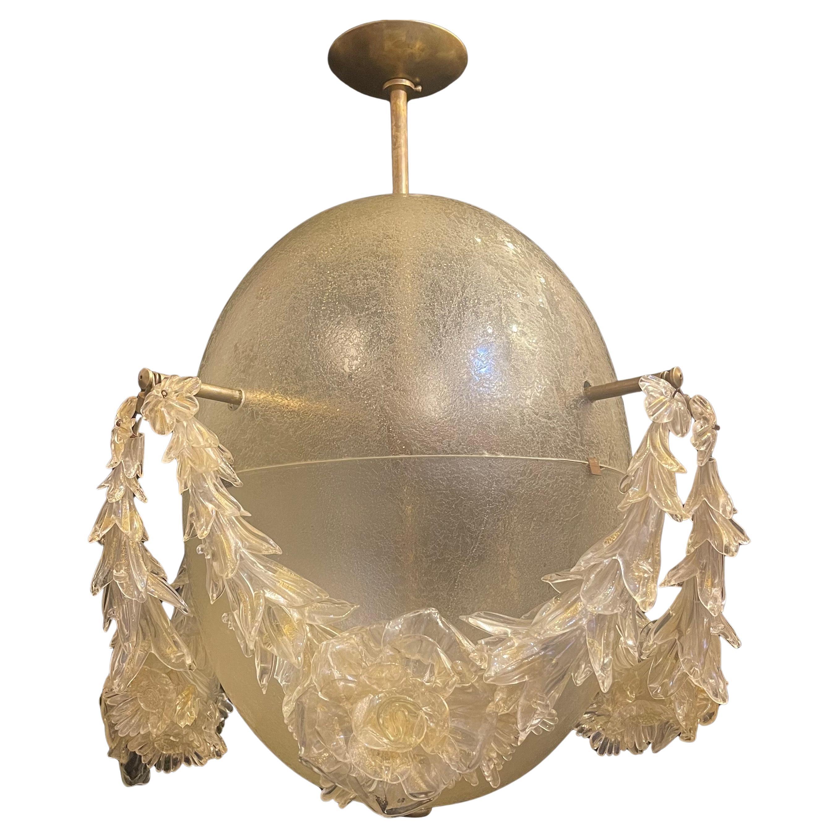Splendido lampadario vintage in vetro artistico di Murano della metà del secolo scorso, con fiori e volute a forma di corona di vetro artistico che circondano l'uovo ovale esterno e 4 luci interne di Edison. L'apparecchio viene fornito con catena,