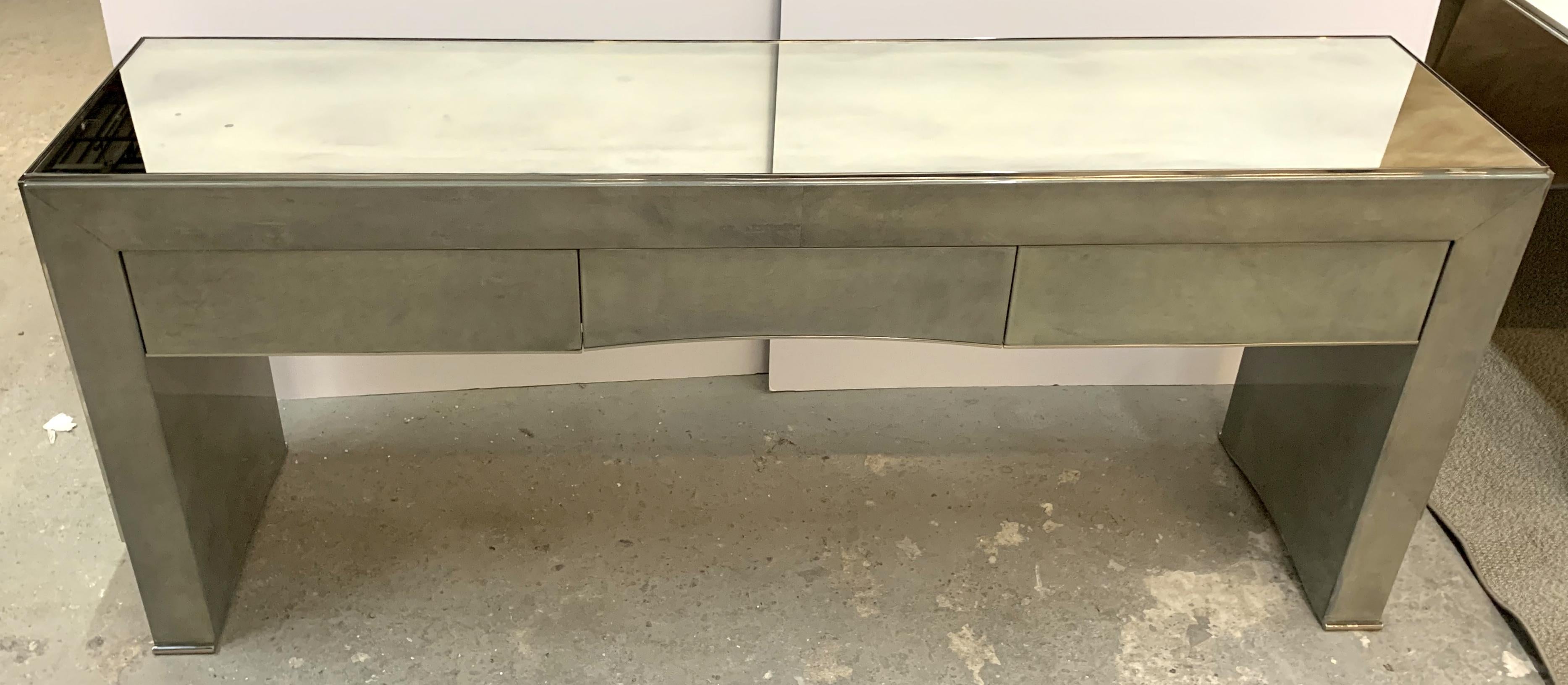 A wonderful Mid-Century Modern soft green goat skin and mirrored polished nickel console table with 3 drawers, finished in the back as well.
Purchased From Lorin Marsh.