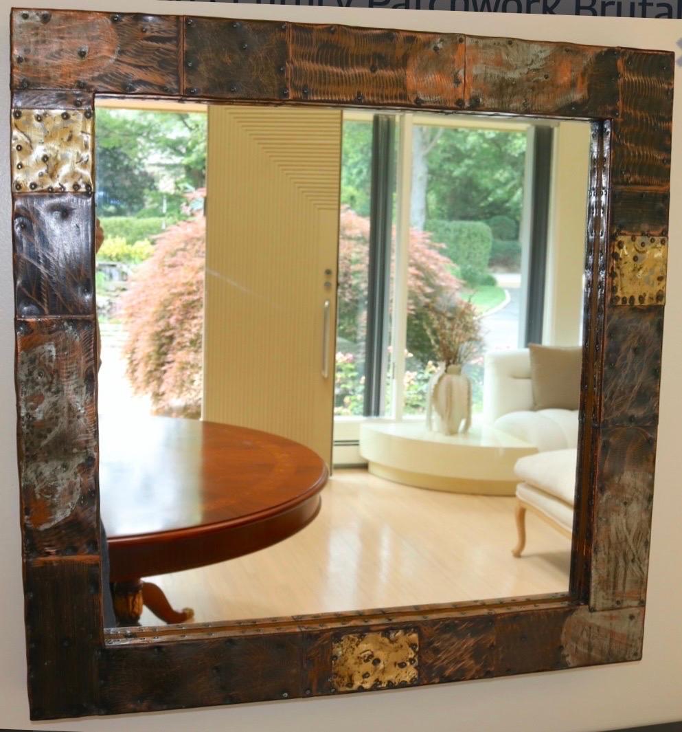 A wonderful Paul Evans studio floating console table and mirror set circa early 1970's. It features copper, bronze and pewter cladding in a patchwork design. Console shelf measures 60 x 13 x 6.5 inches with heavy black slate top. 
Mirror measures 30