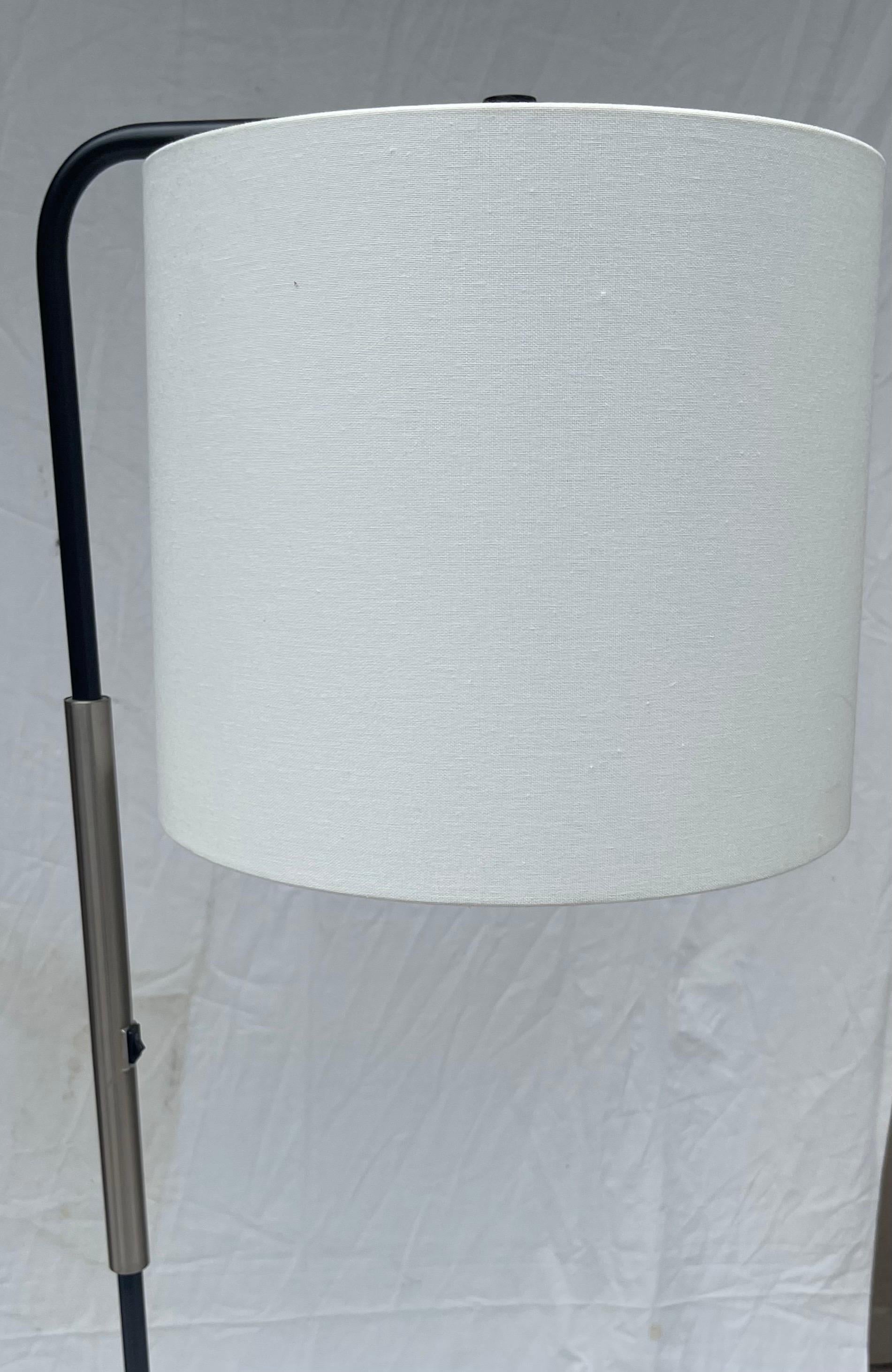 Una meravigliosa lampada da terra moderna con rivestimento a polvere nera e nichel e paralume a tamburo bianco