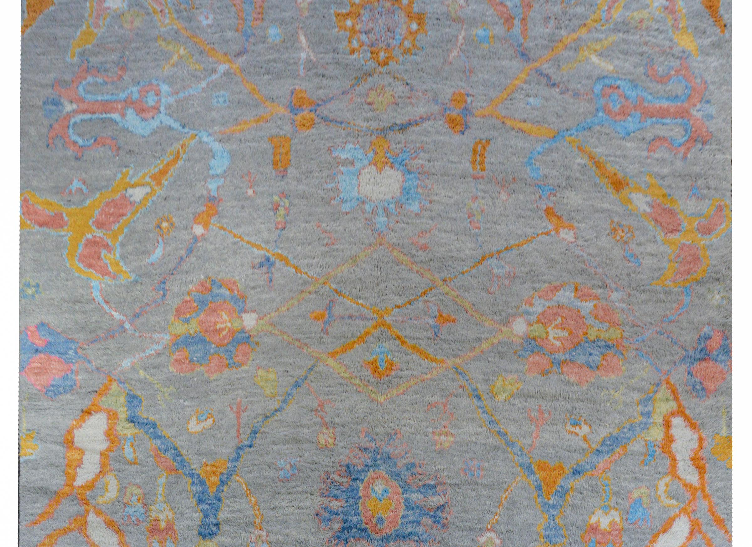 A wonderful contemporary Anatolian Turkish Tulu rug with an all-over multicolored stylized vine and floral pattern a gray background, woven with a thick shaggy pile.