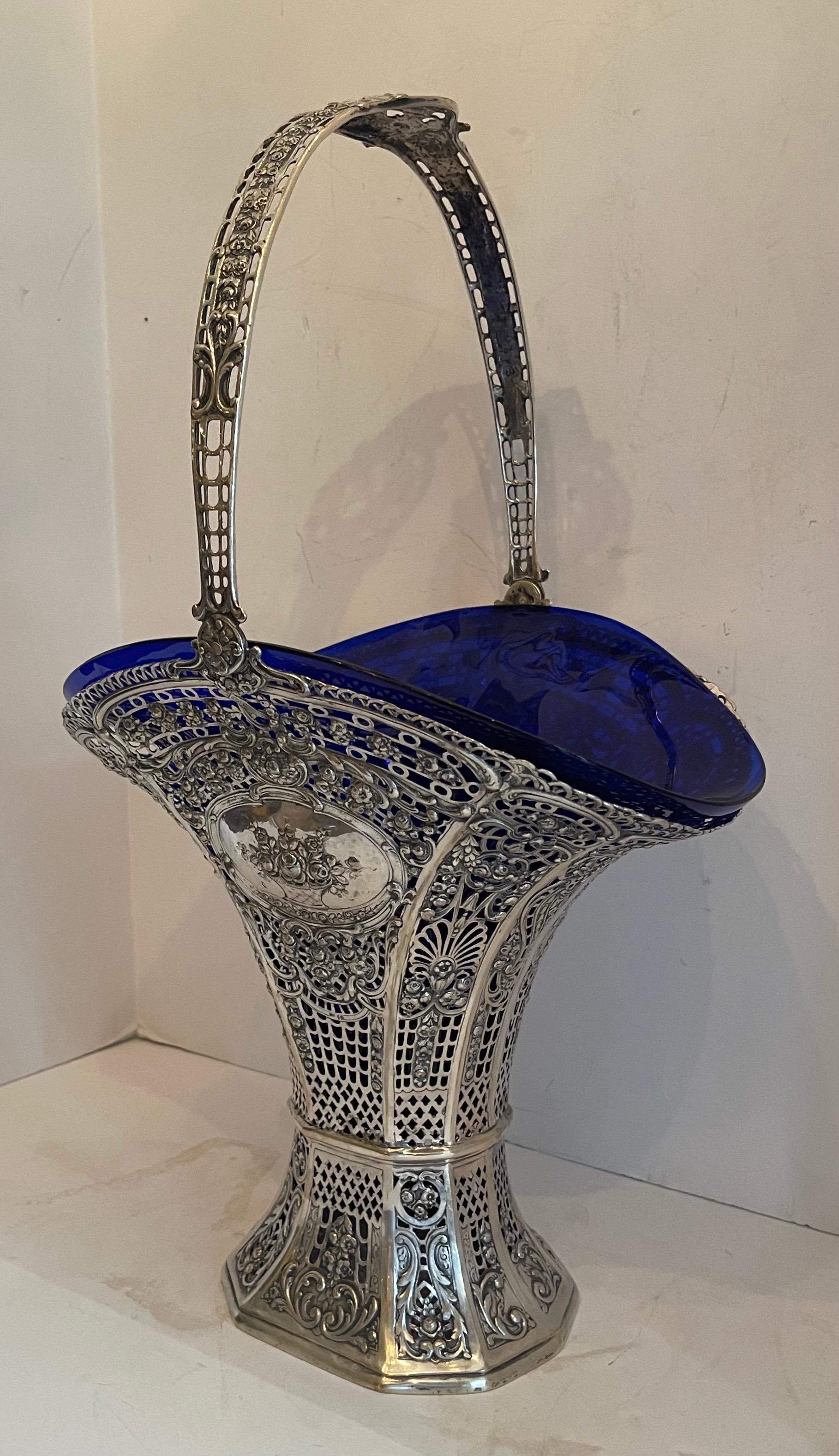 A rare and wonderful monumental large European sterling silver pierced bridal basket with open work handle inset with a beautiful cobalt blue glass.