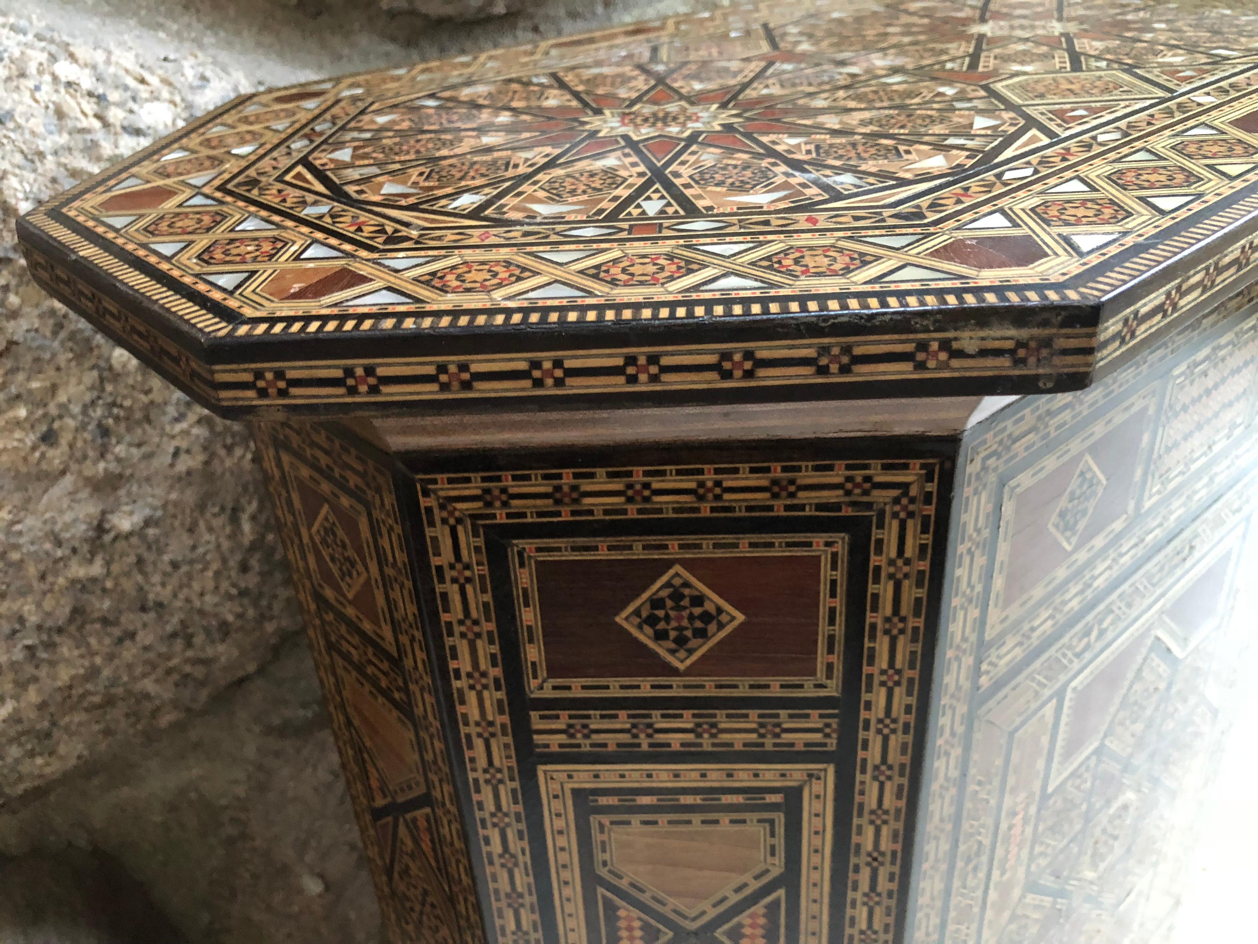 Striking hand made Moroccan side table with door that reveals storage inside. Comprised of inlaid teak wood and mother-of-pearl, table is remarkably detailed and is in excellent condition.