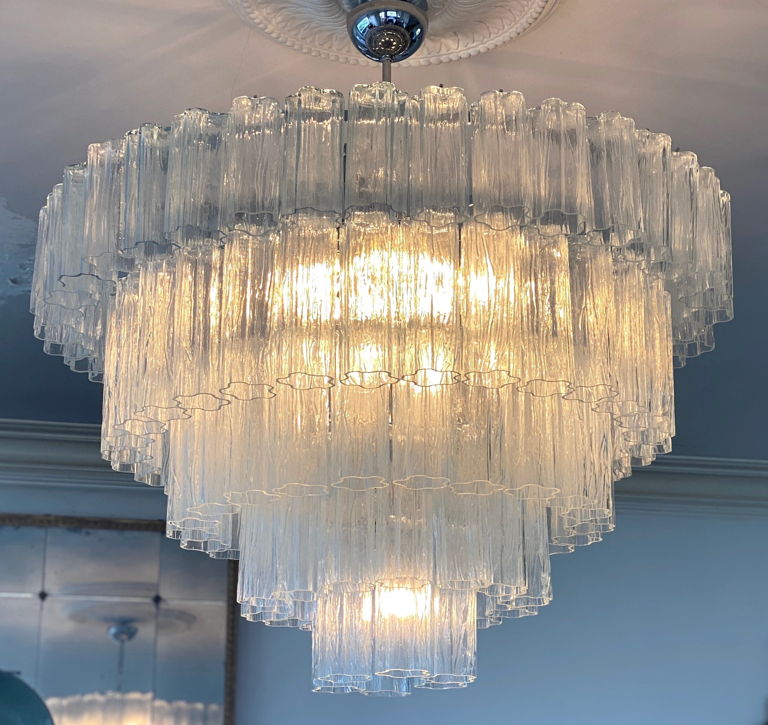 Spettacolare lampadario composto da circa  100 tronchi cilindrici in vetro soffiato a mano alla maniera di Tony Zuccheri per Venini.
Altezza regolabile, rimuovendo o aggiungendo le maglie della catena.
12 lampadine E 14. Possiamo ricablare secondo