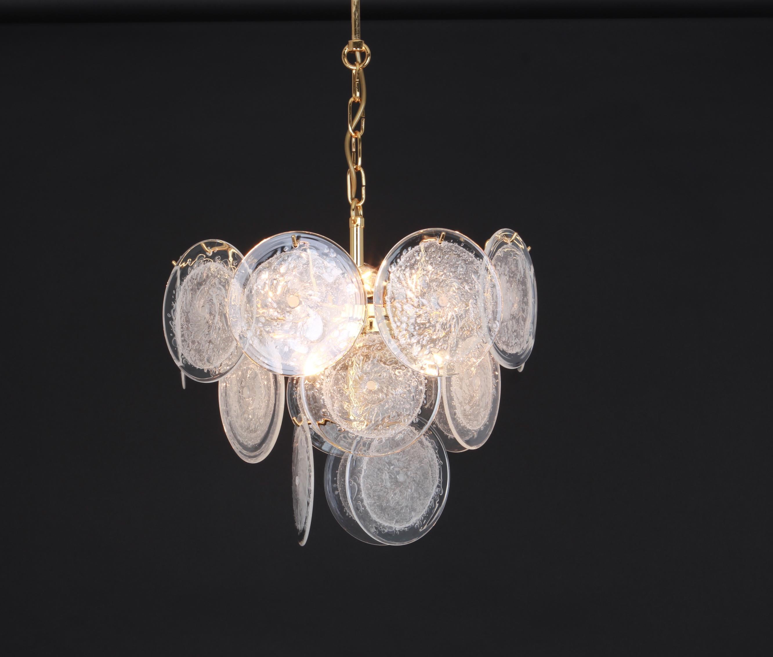 Wonderful ice glass disc chandelier by Vistosi, Italy, 1970s.

This spectacular mouth-blown glass disc chandelier is characteristic of the design vocabulary of Gino Vistosi: simple, geometric shapes and monochrome colors executed in the cased