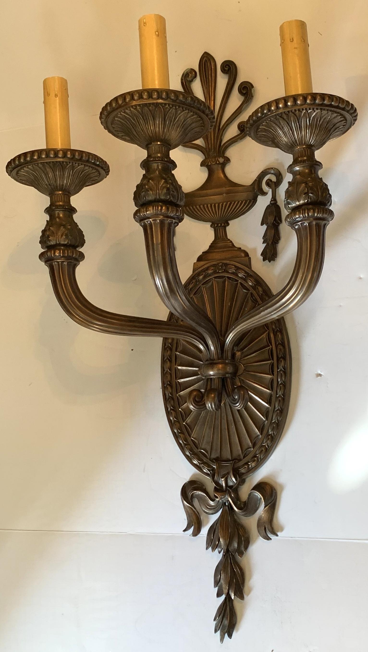 A wonderful neoclassical pair of patinated bronze large urn form top and oval back 3 light sconces rewired and ready to enjoy, very fine cast and detail.
We have had this model sconces by Caldwell, but this pair is unsigned.