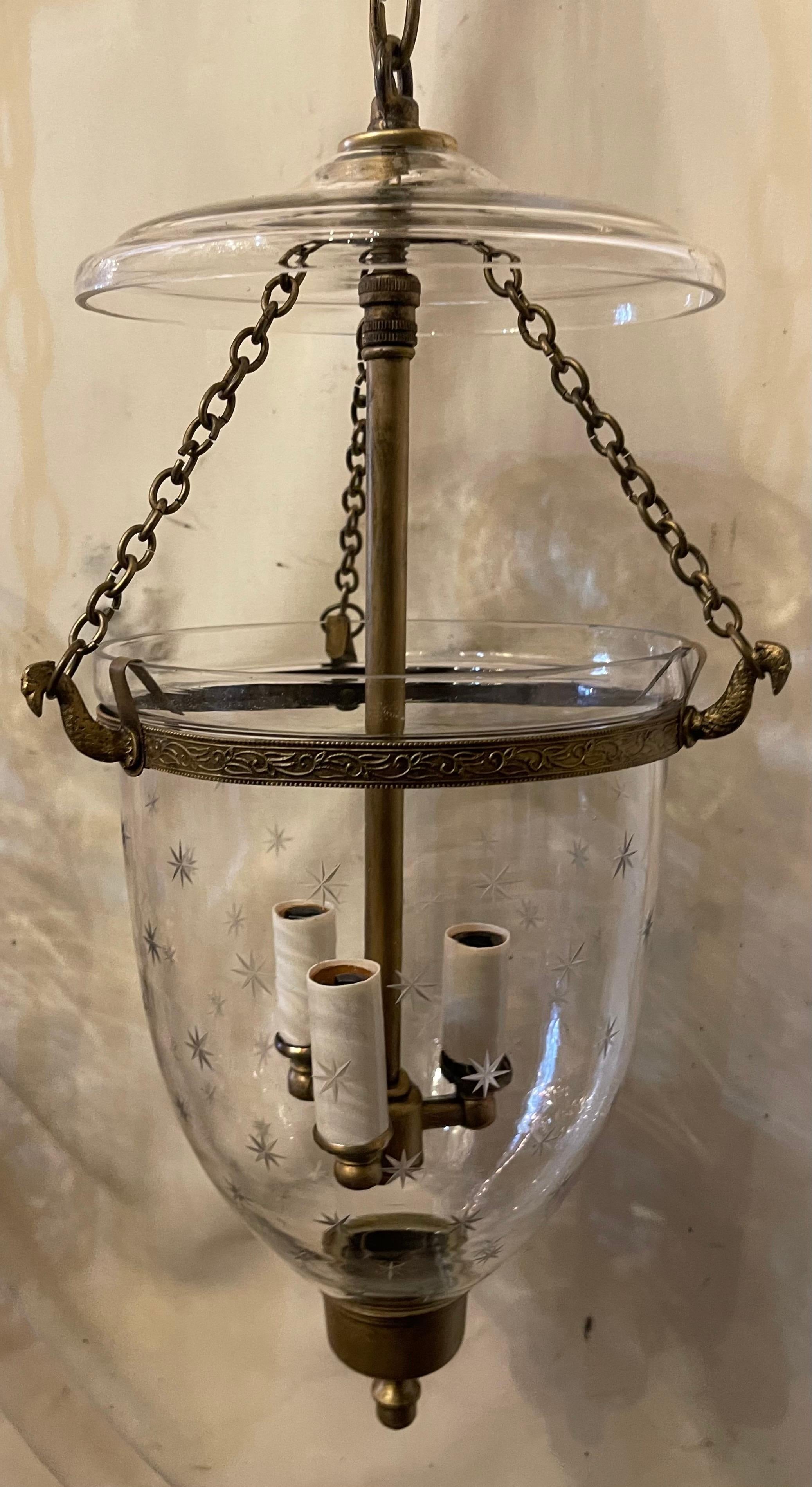 Merveilleuse paire de lanternes en forme de clochettes en laiton doré et en verre soufflé et gravé, chacune dotée d'une grappe de trois candélabres à la manière de Vaughan. Chaque luminaire est prêt à être suspendu avec une chaîne et un baldaquin.
