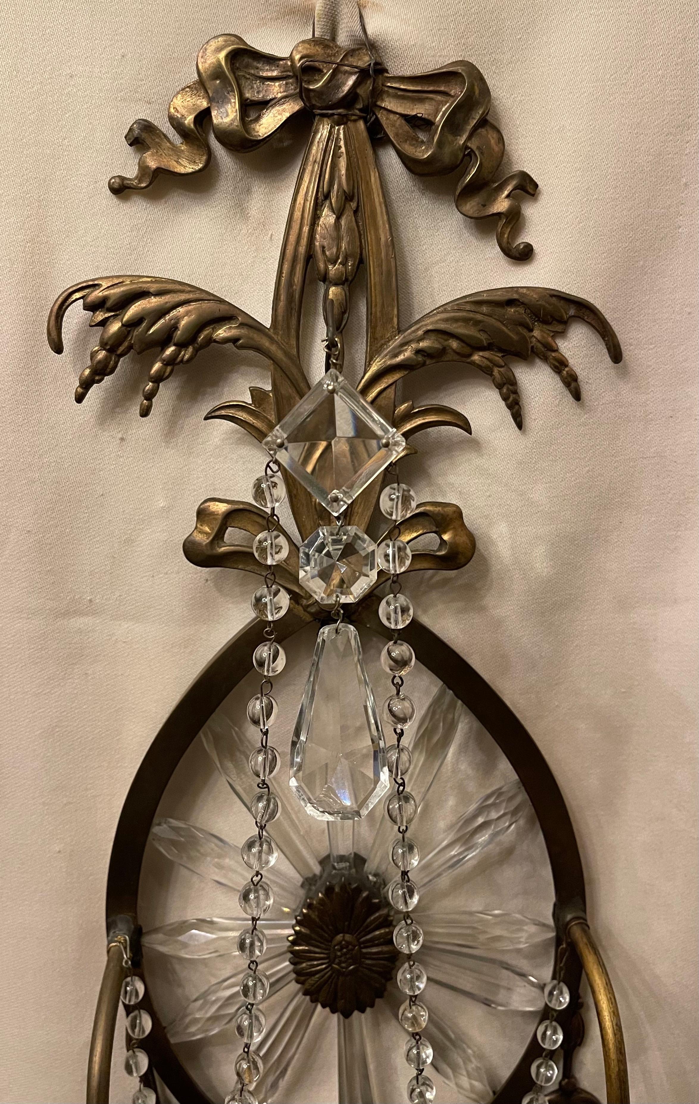 A wonderful pair of Caldwell style sconces with bow top and elegant crystal sunburst star oval back and fine bronze neoclassical frame. This pair of sconces has two candle arms and are in the manner of Robert Adam.

Wiring is available.
