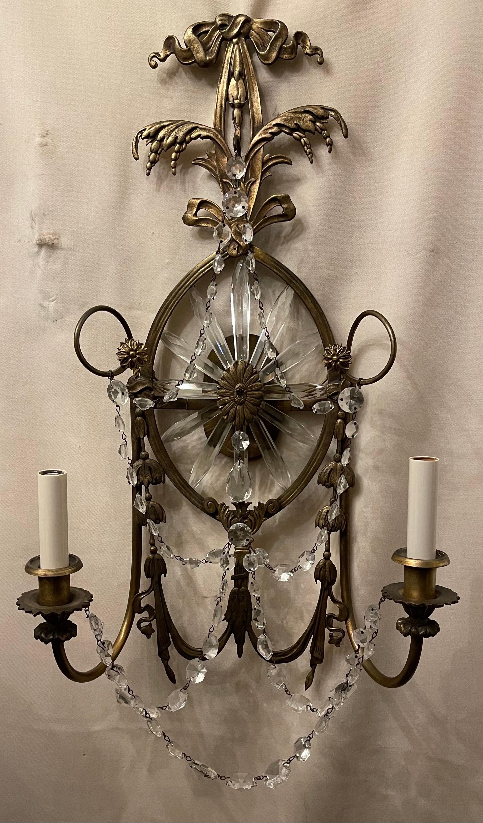 A wonderful pair of Caldwell style and quality bronze bow top & swag with crystal sunburst star centerpiece elegant sconces each with two candelabras sockets that have been rewired.
 
 
