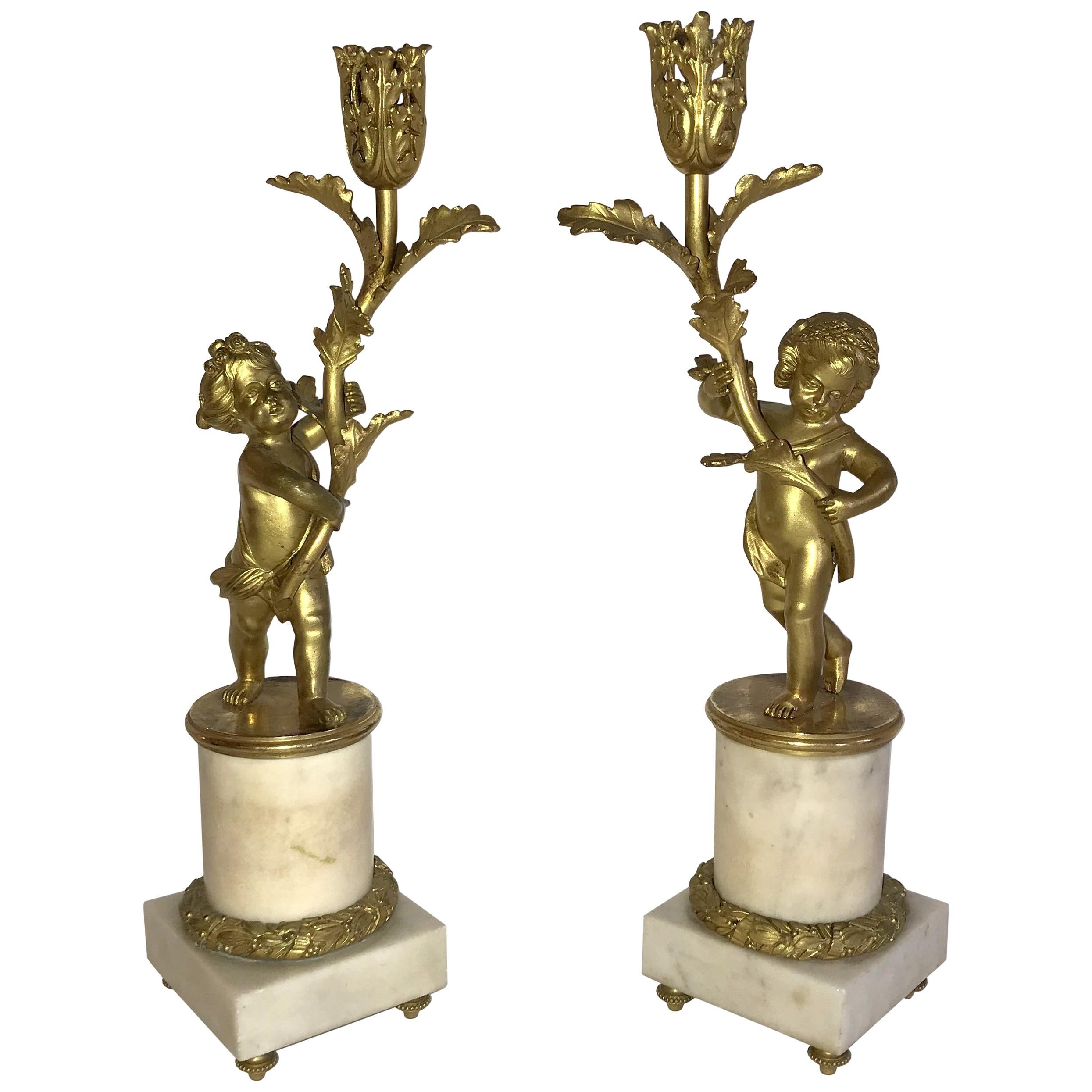 Merveilleuse paire de chandeliers Putti en bronze doré et marbre monté en bronze doré en vente