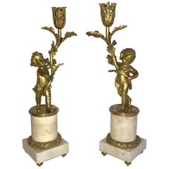 Merveilleuse paire de chandeliers Putti en bronze doré et marbre monté en bronze doré