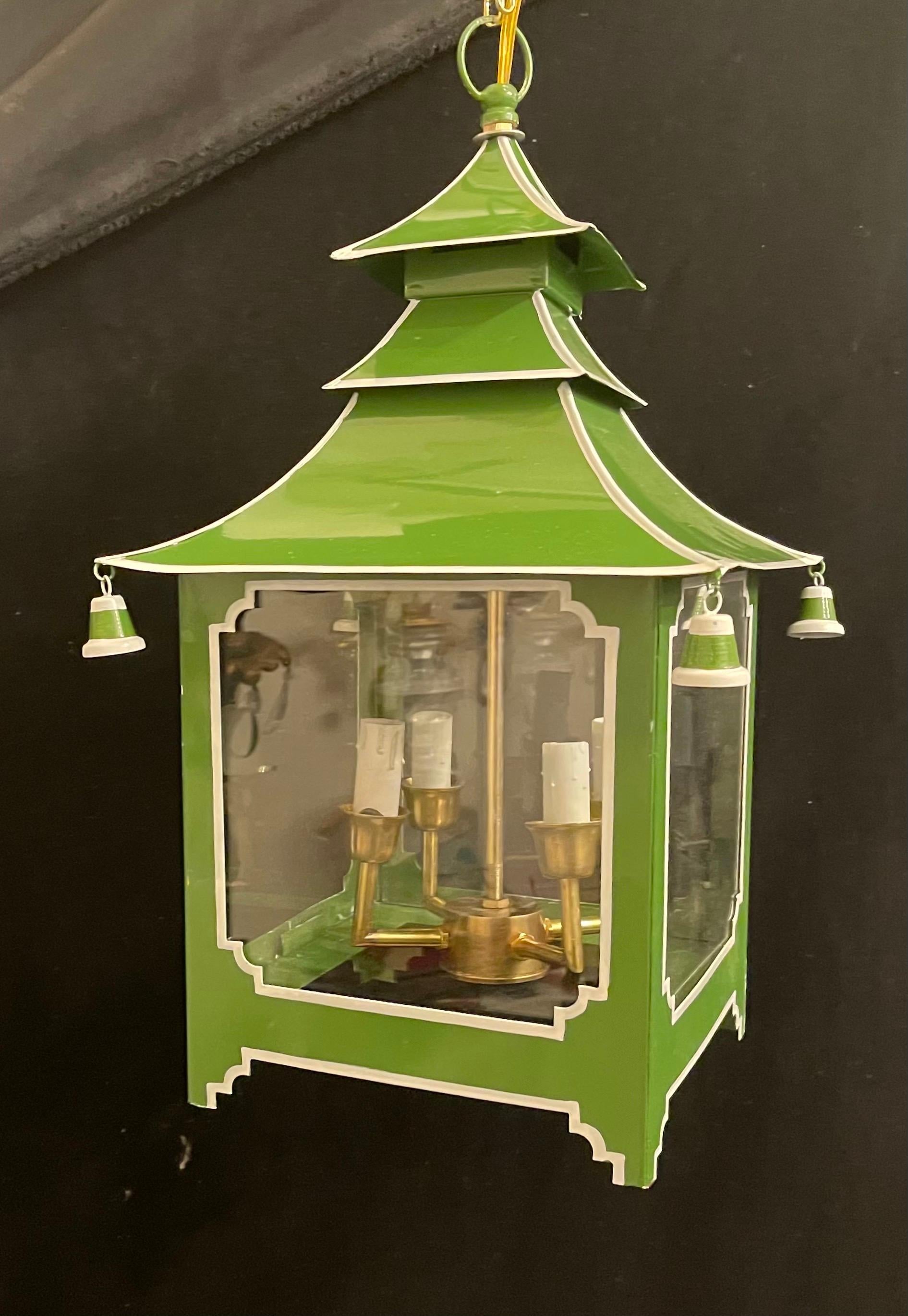 A wonderful pair of chinoiserie pagoda form green apple enameled with white trim glass insert lantern fixtures. Accompanied by chain and canopy as well as mounting hardware for installation.

Each sold separately.