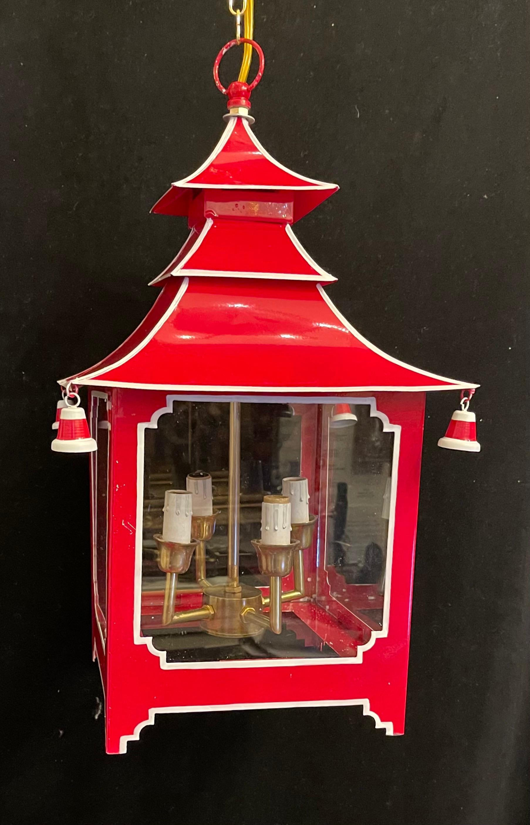 A wonderful pair of chinoiserie pagoda form red enameled with white trim and glass panel lantern fixture fitted with four candelabra sockets.
Accompanied by chain and canopy as well as mounting hardware for installation.

Each sold separately.