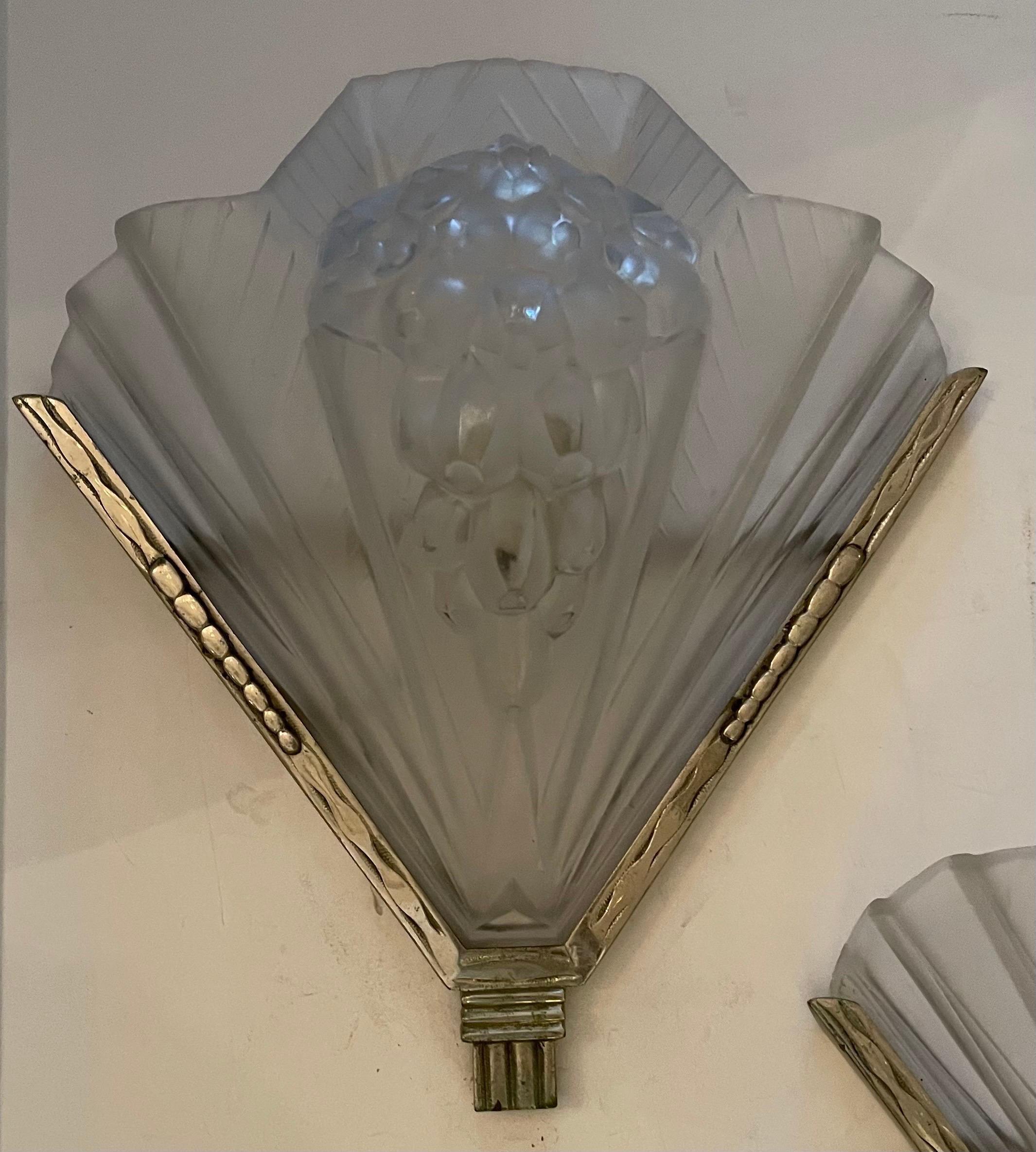 Stunning pair of French Art Deco signed Atelier Petitot sconces. Shades are in clear frosted glass with over flowing intricate geometric motif details. Each shade is marked 