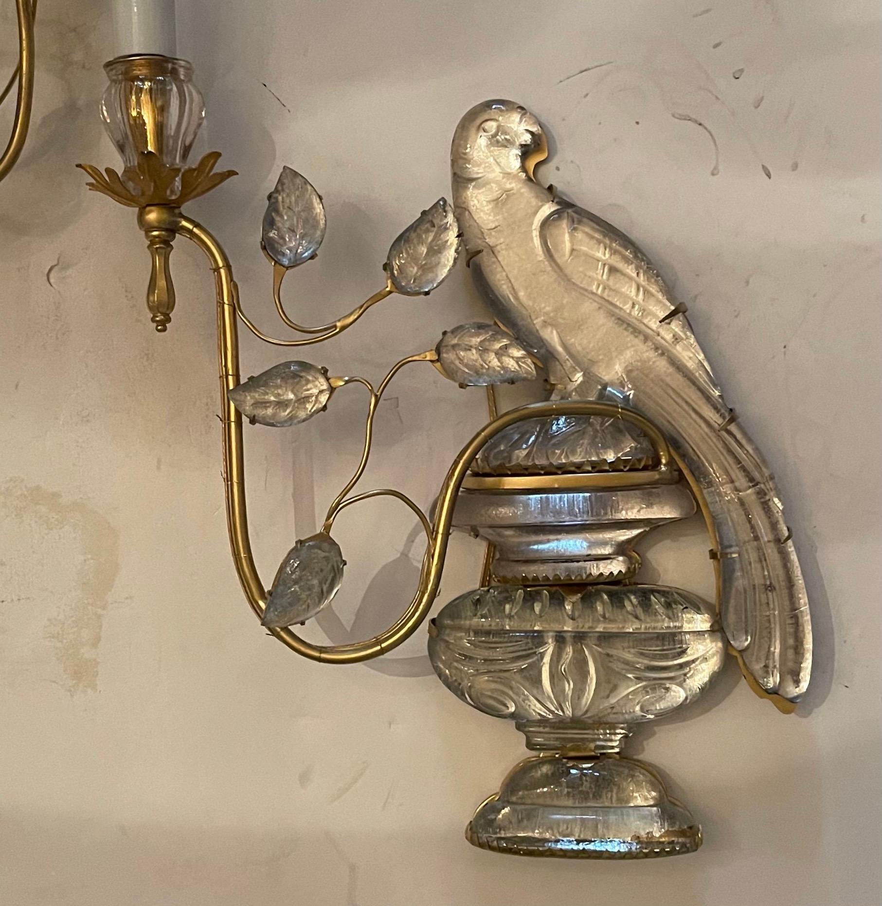 A wonderful pair of French Baguès vintage gilt bronze & faux glass rock crystal parrot / bird form sitting on urns surrounded by leaves and branches sconces, completely rewired with new sockets.