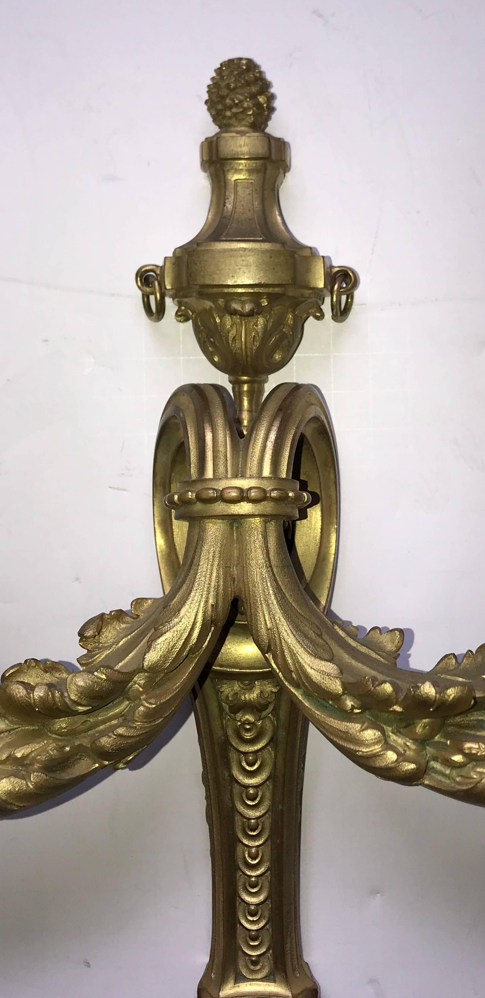 A wonderful pair of French bronze neoclassical / Regency urn top and filigree sconces in the manner of Caldwell, stamped made in France on the backs.