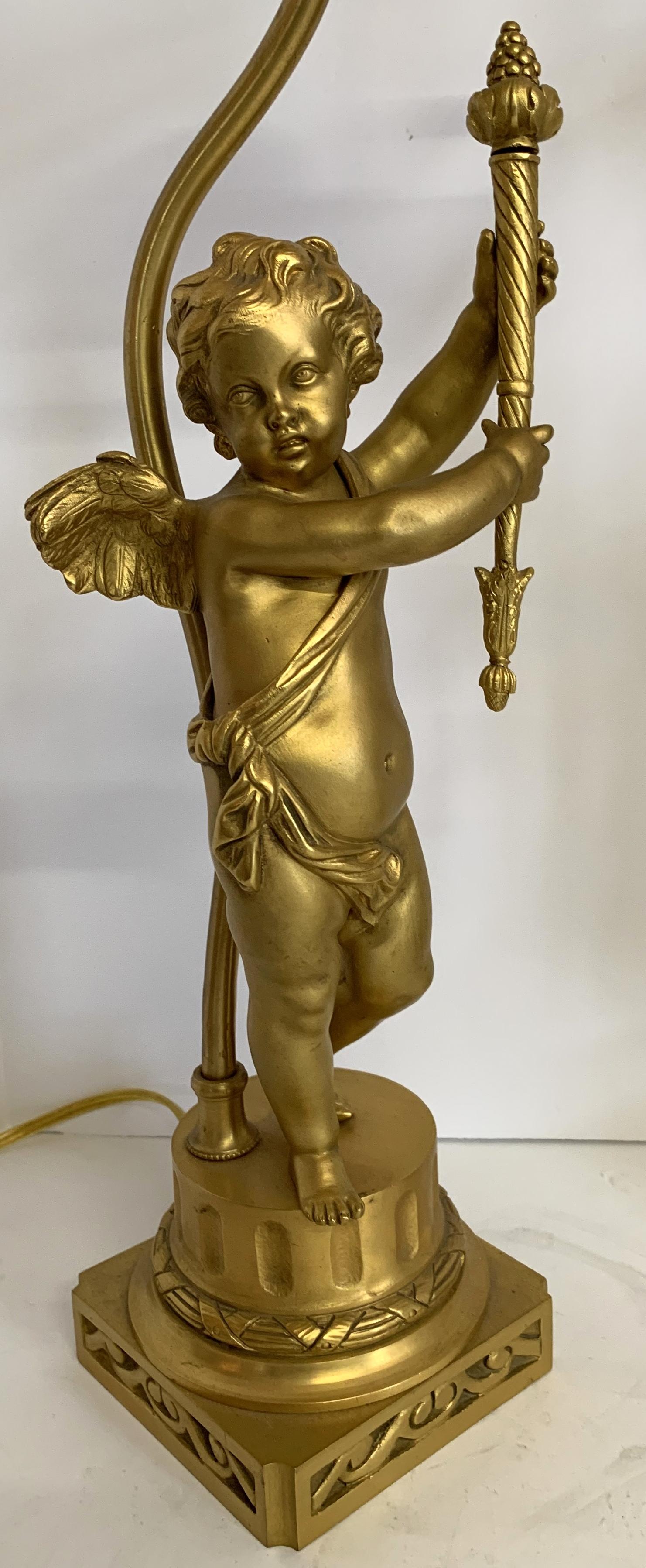 Une merveilleuse paire de sculptures figuratives françaises en bronze doré avec des chérubins ailés / putti tenant des torches converties en lampes.