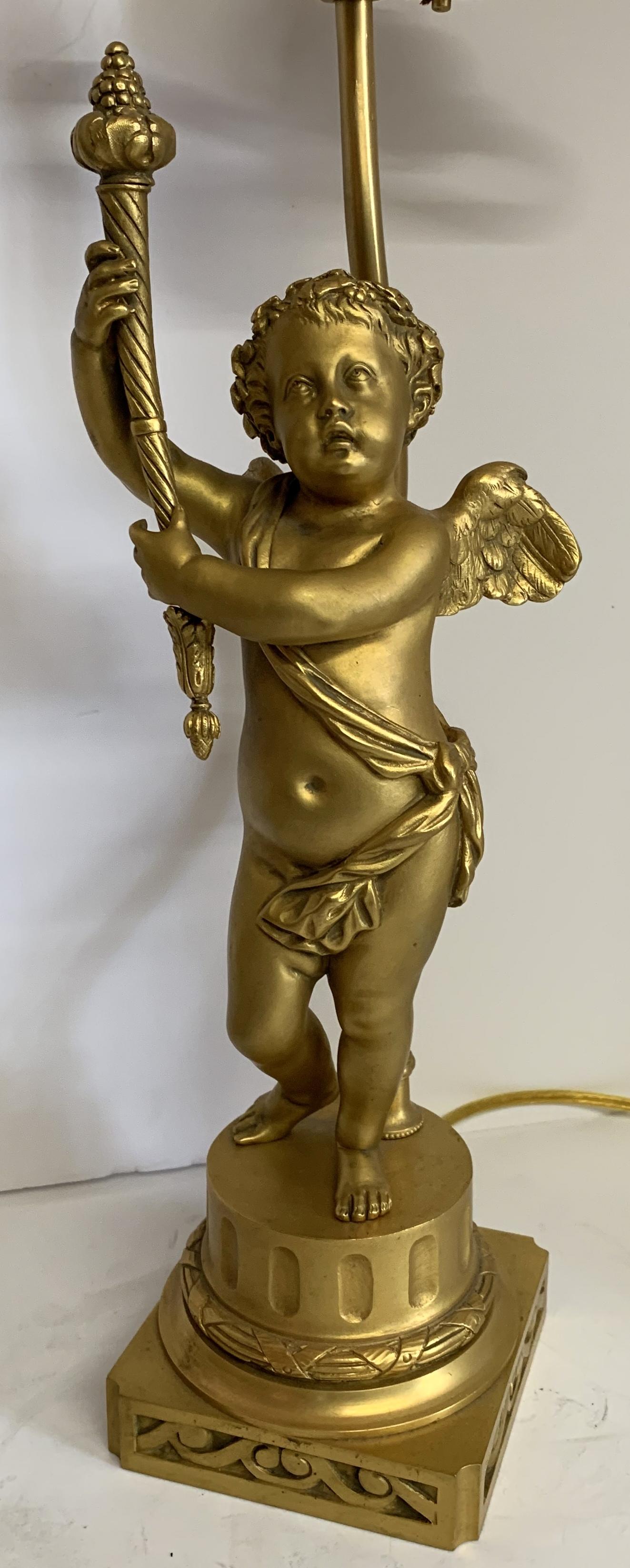 Belle Époque Merveilleuse paire de lampes torchs figuratives françaises en bronze doré représentant des chérubins Putti en vente