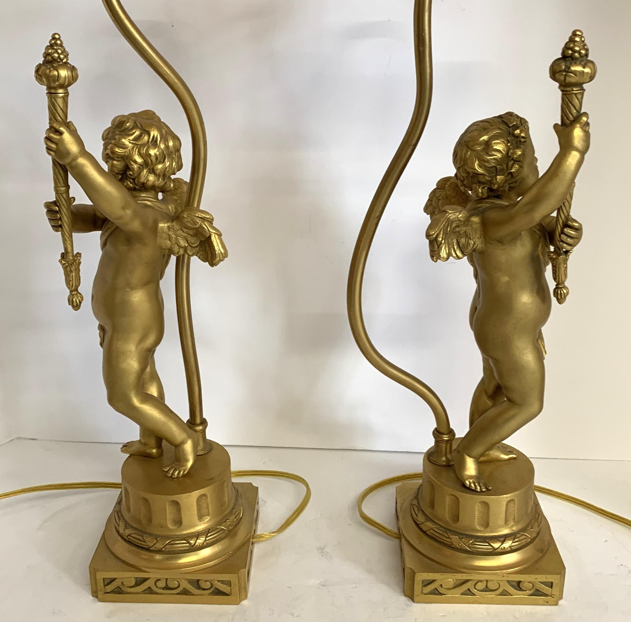 Doré Merveilleuse paire de lampes torchs figuratives françaises en bronze doré représentant des chérubins Putti en vente
