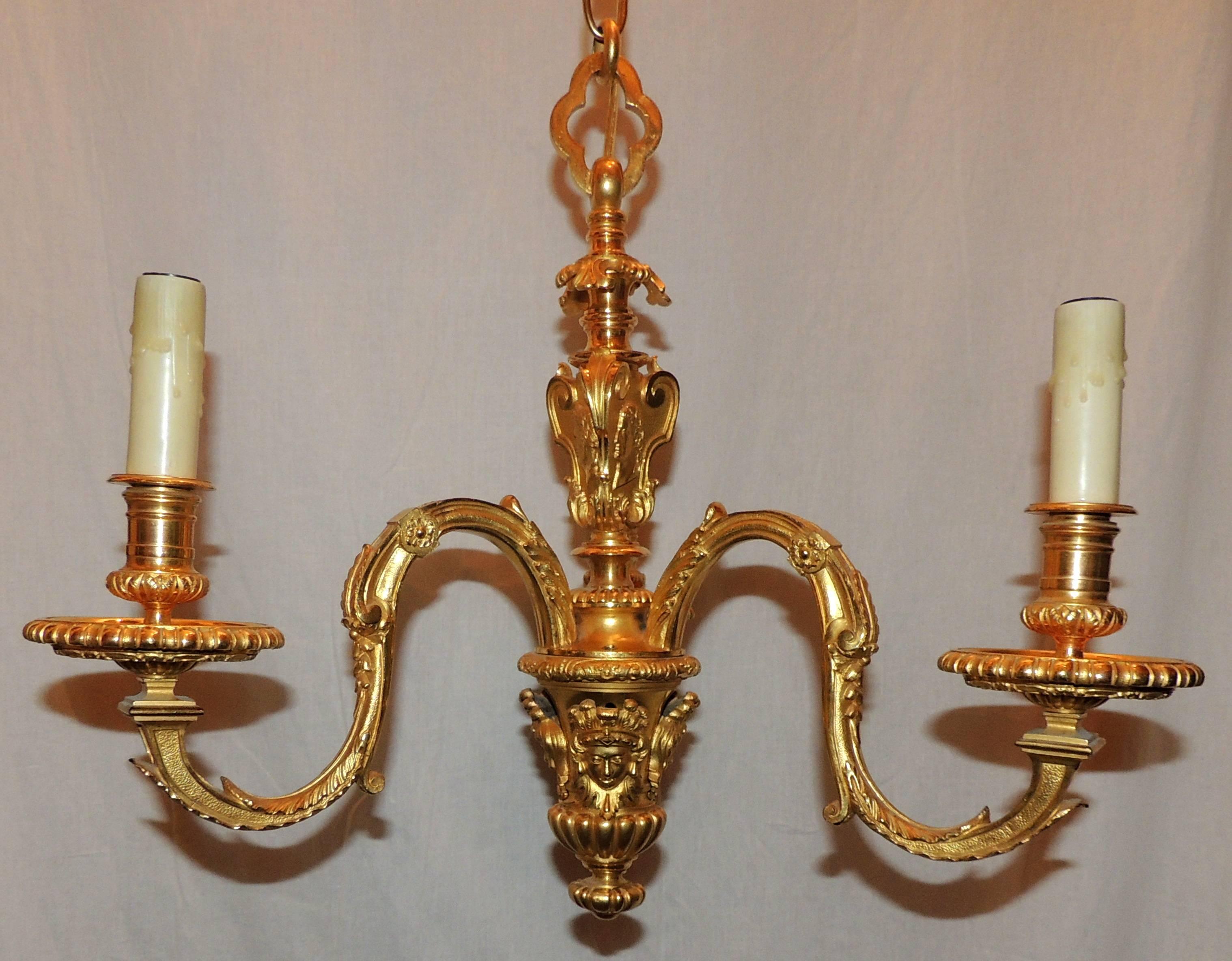 A wonderful pair of French doré bronze, petite neoclassical / Empire pendant chandeliers with three lights each that have been rewired and come with all mounting hardware ready to install.