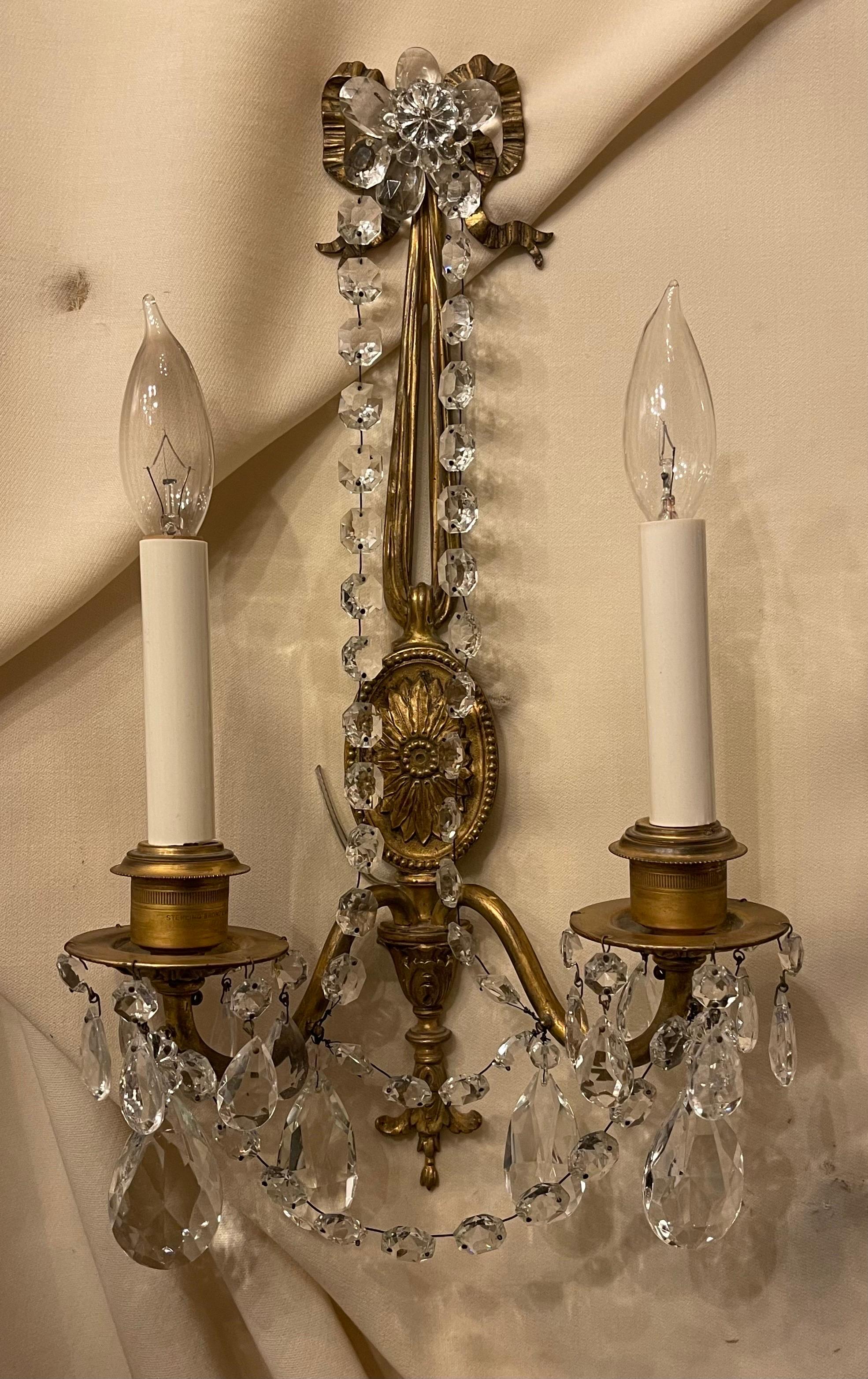 A wonderful pair of french gilt bronze & crystal strand bow top and tassel two candelabra light sconces In The Manner Of Caldwell

Rewired With New Sockets And Come Ready TO Install With Mounting Brackets.