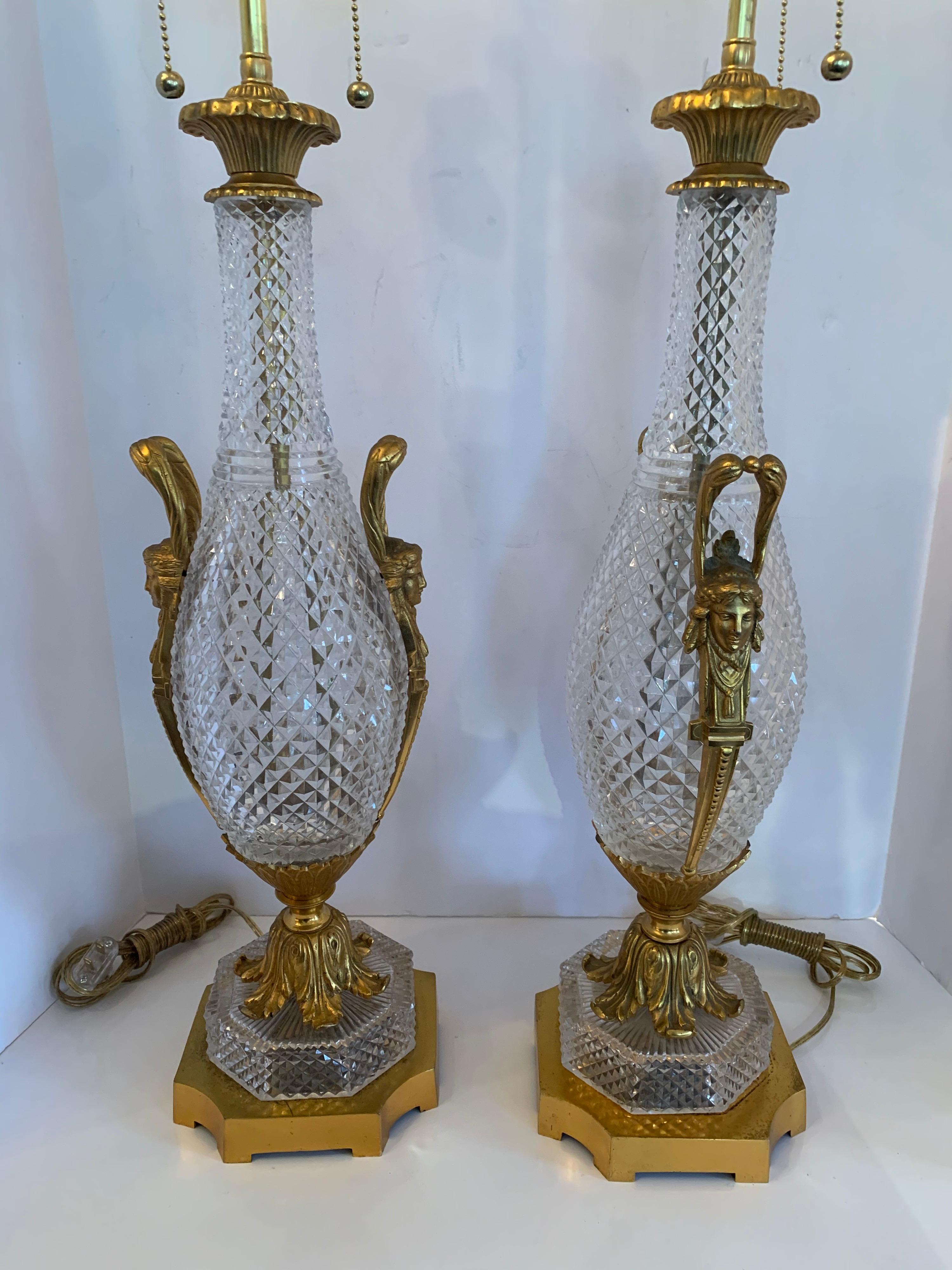 A wonderful pair of French gilt dore bronze & diamond cut crystal urn form lamps in the manner of baccarat.
