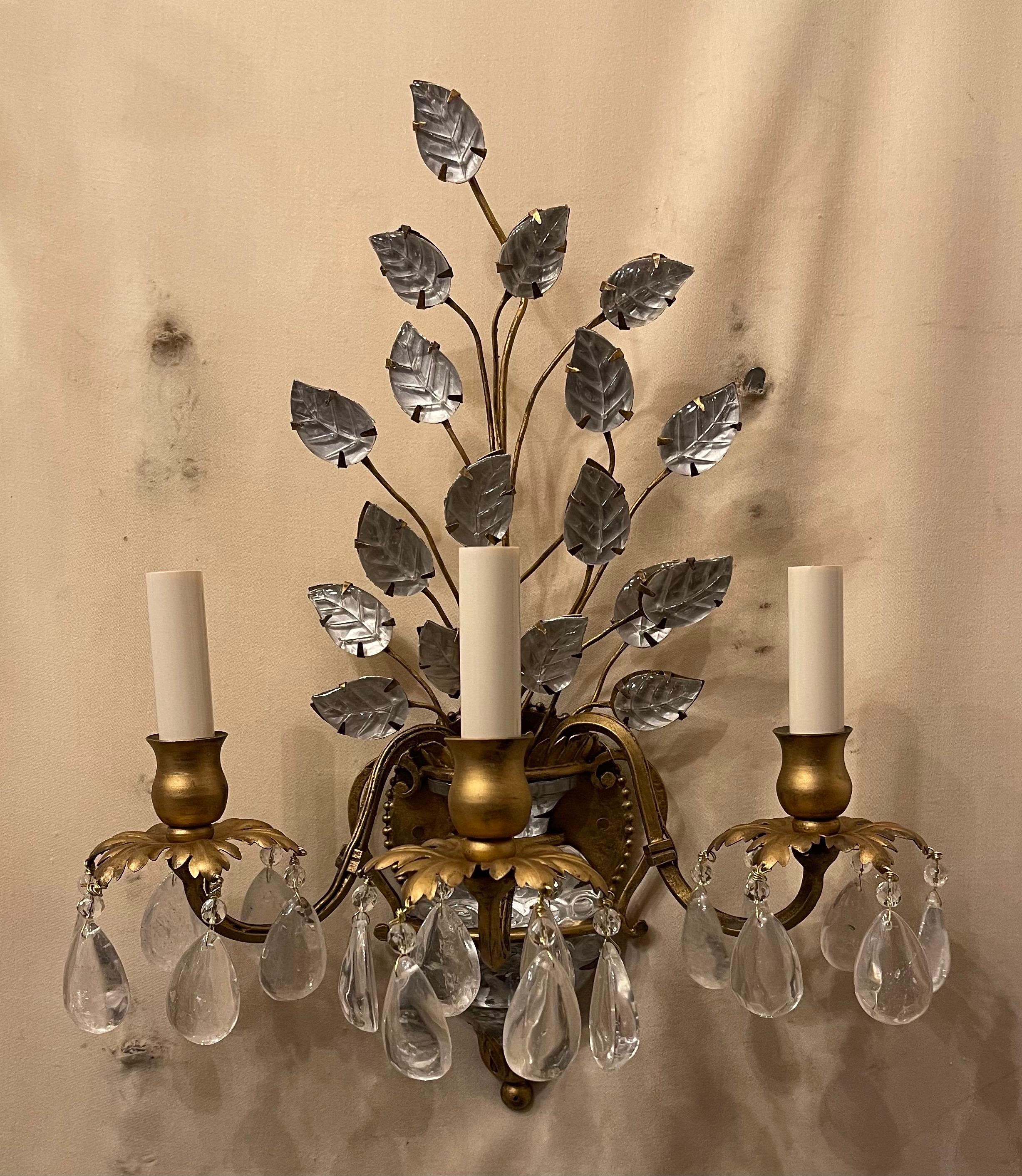 A wonderful pair of vintage French gold gilt rock crystal drop and faux urn sconces having a lovely leaf spray bouquet, each with 3 candelabra lights, rewired and ready to install with mounting hardware.