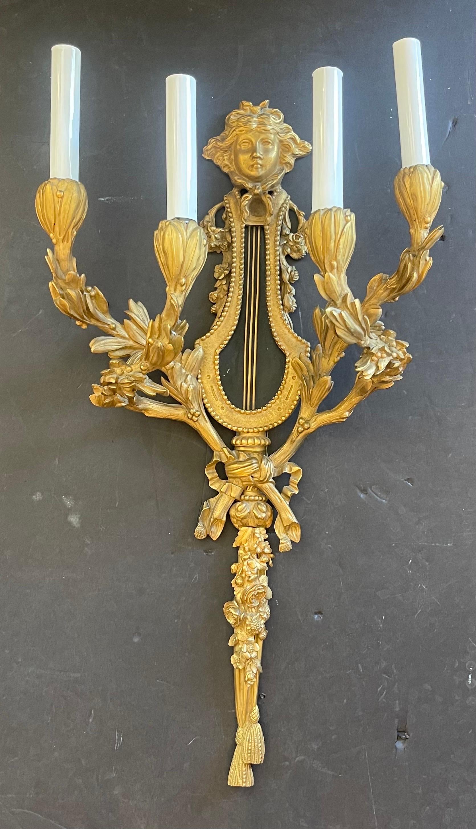 Merveilleuse paire d'appliques murales en bronze doré à quatre candélabres de style Louis XVI du XIXe siècle, avec un masque de Méduse au centre au-dessus d'une lyre, d'après le modèle de Pierre Gouthière / Attribué à Henry Dasson.