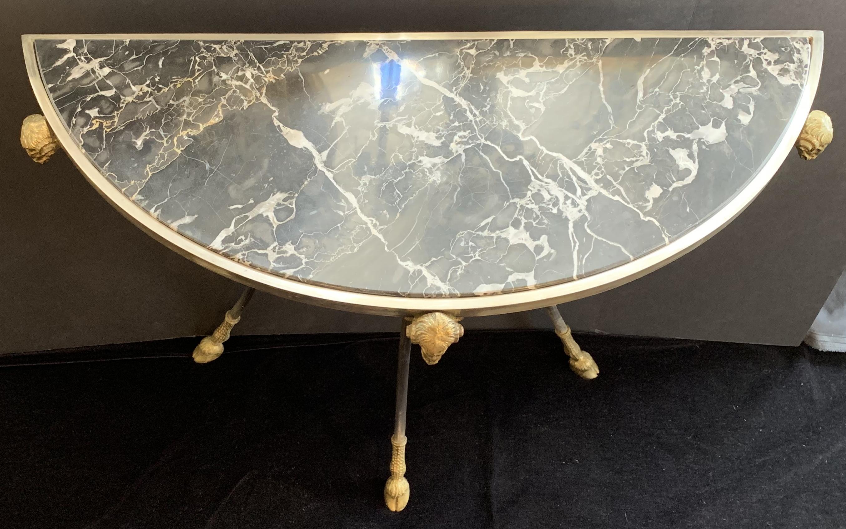 A wonderful pair of Jansen style demilune marble top inset ram's head and foot ormolu-mounted with brushed nickel console tables.