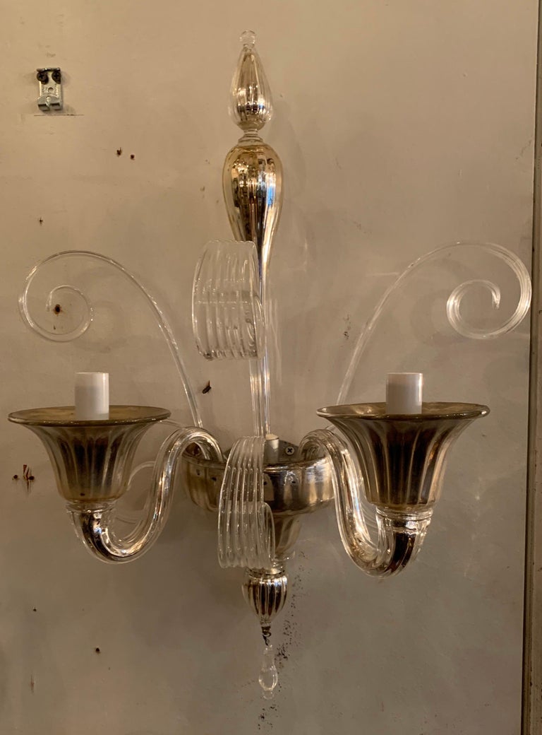 A wonderful pair of Mid-Century Modern two candelabra light Murano silver tone glass sconces with six ribbons, a center spike & flared bobeches.
