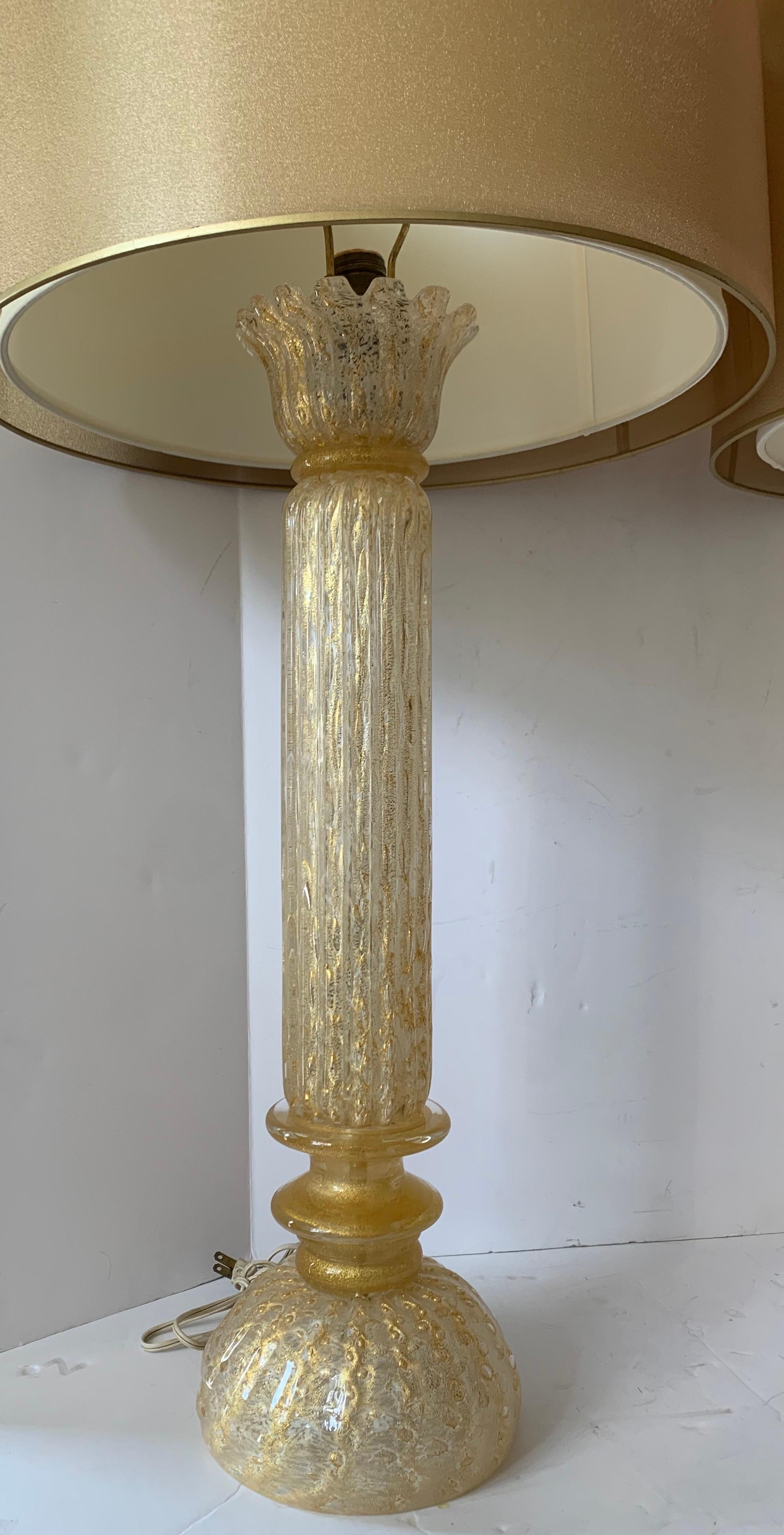 A wonderful pair of Mid-Century Modern Italian Murano Venetian gold flake table lamps accompanied by a beautiful pair of two layered gold shades.