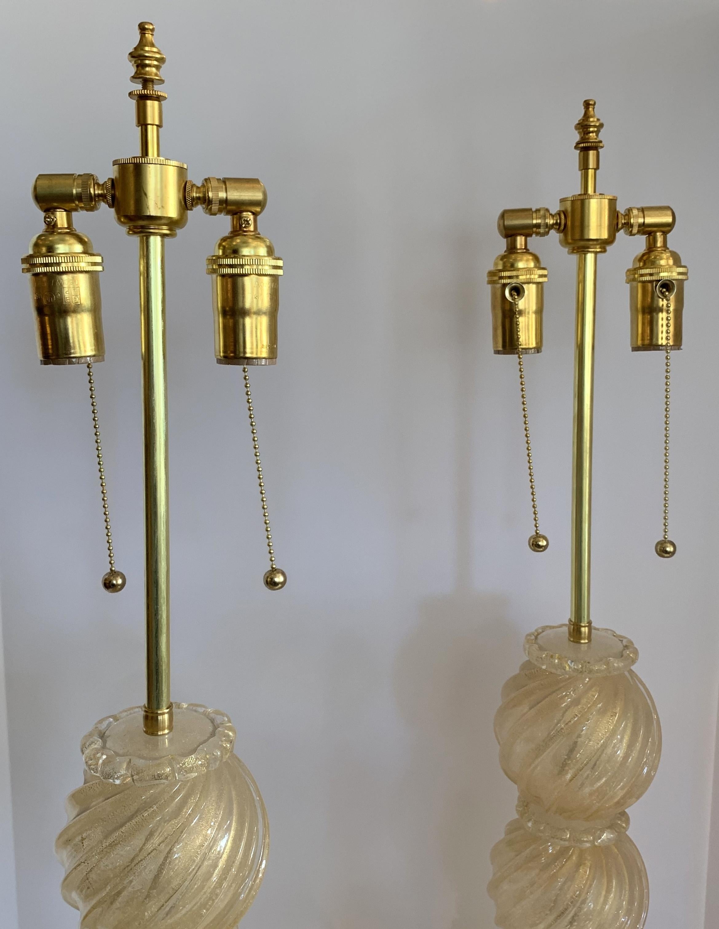 A wonderful pair of Mid-Century Modern Italian / Murano Venetian swirl form gold flake and clear color art glass lamps in the art deco style with new brass fittings and wiring.
Purchased from Lorin Marsh.