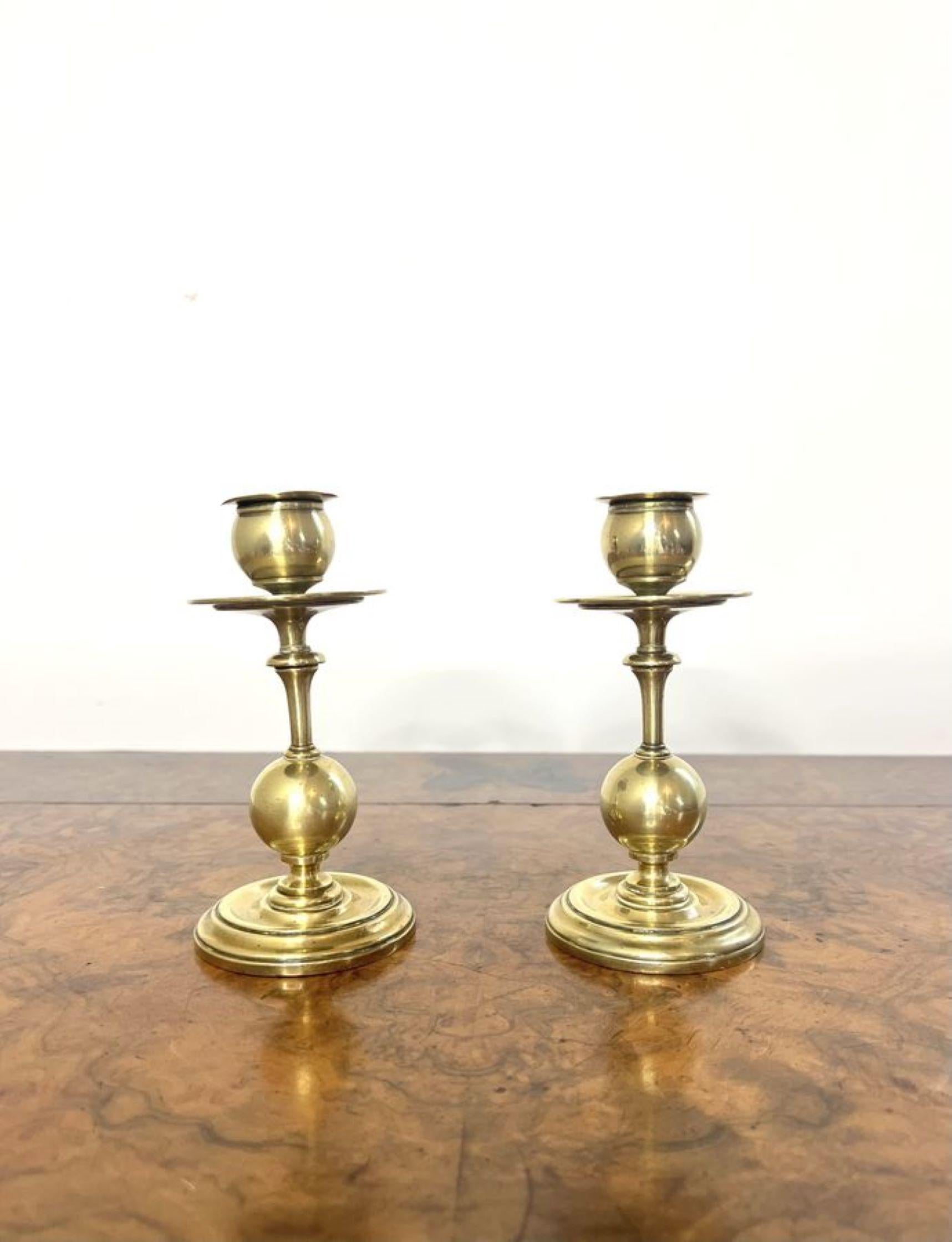 Wonderful pair of arts and crafts brass candlesticks having a wonderful pair of brass candlesticks, with brass drip trays to the top a circular brass ball to the bottom and circular bases.

D. 1910