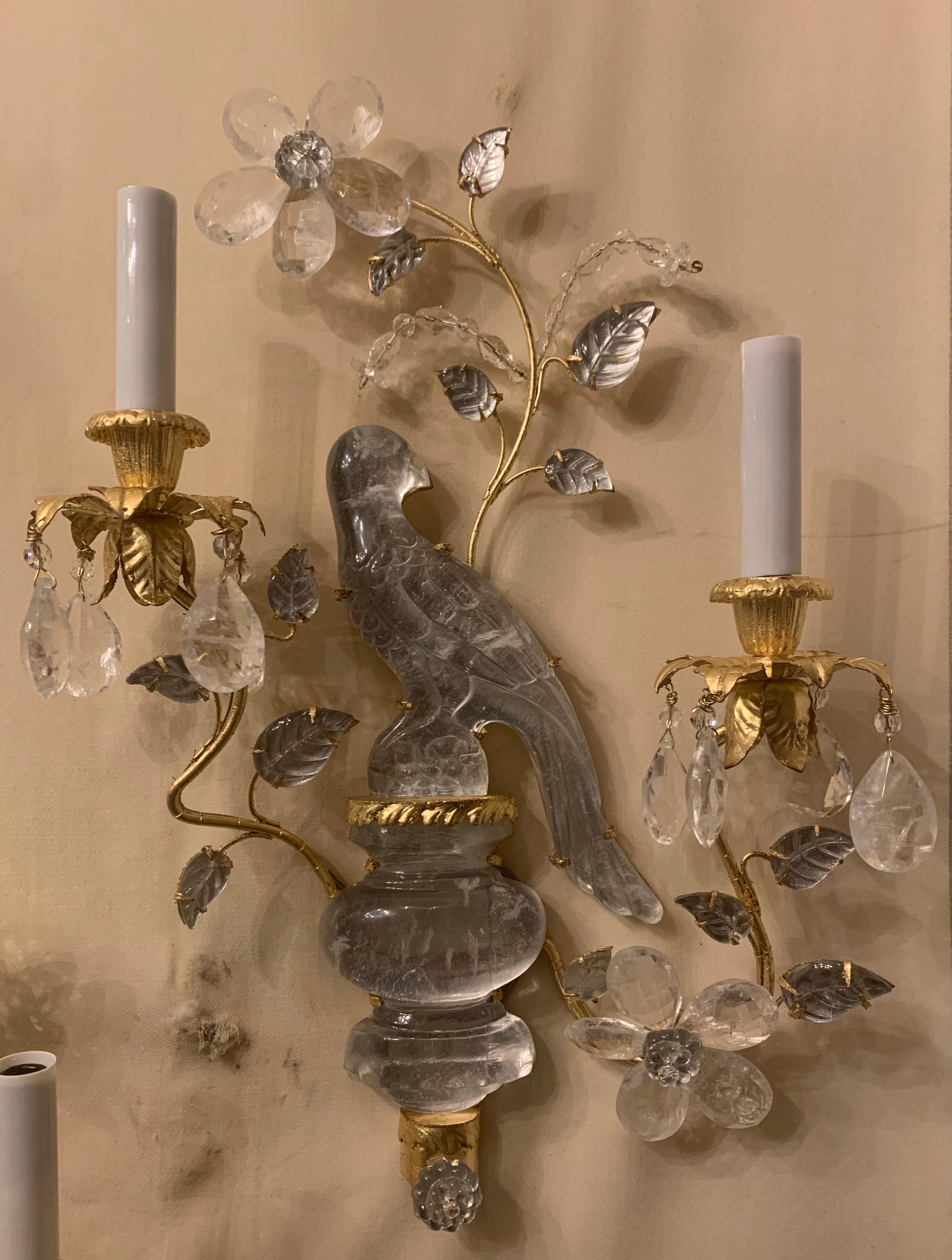A wonderful pair of Baguès style two-arm rock crystal bird / parrot urn form gold gilt sconces adorned with leaves and flowers, newly rewired with candelabra sockets each pair has a right and left facing bird.

Second pair also available.