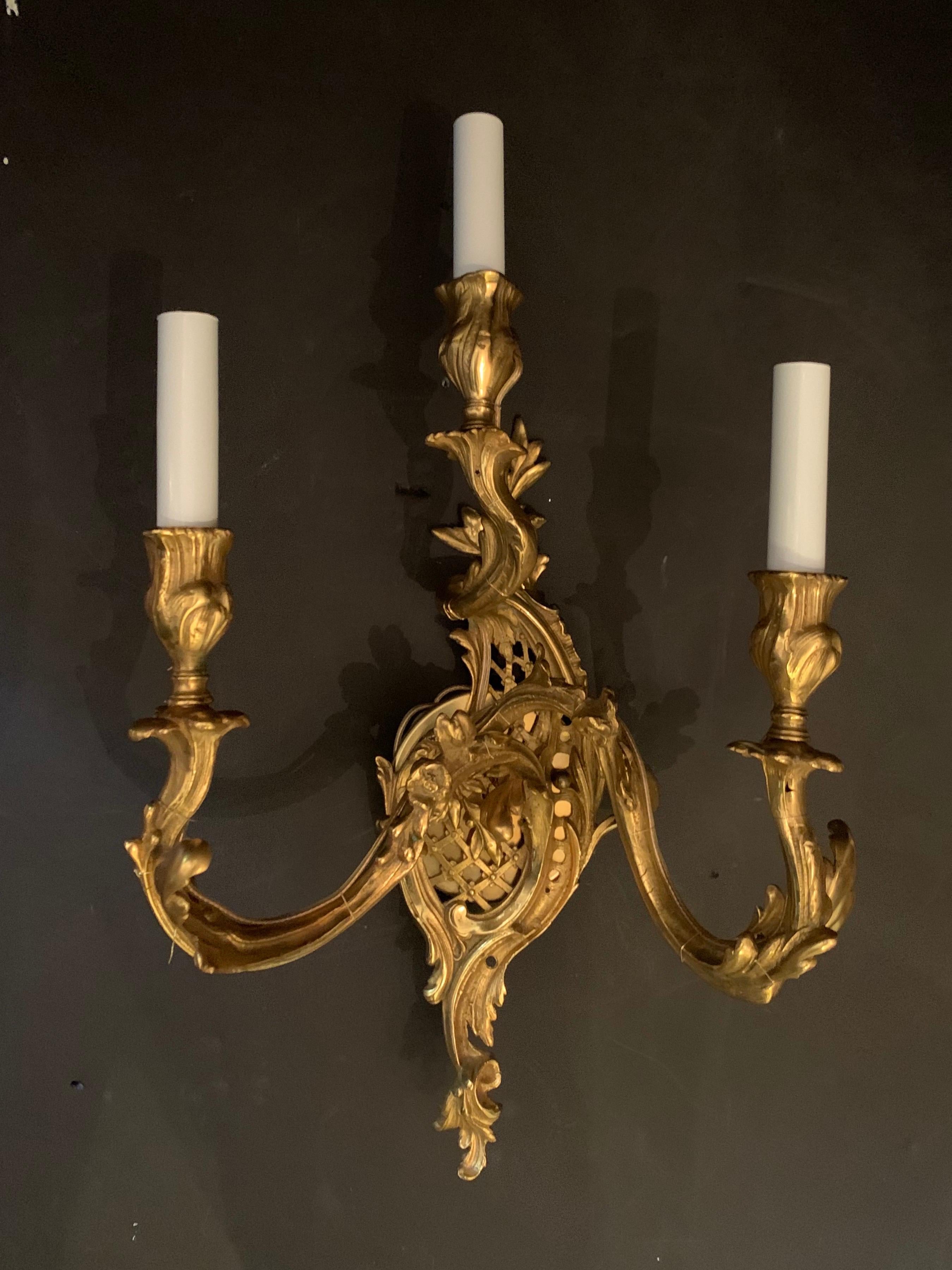 A wonderful pair of French dore bronze Rococo style three candelabra light lattice back sconces, rewired with new sockets.