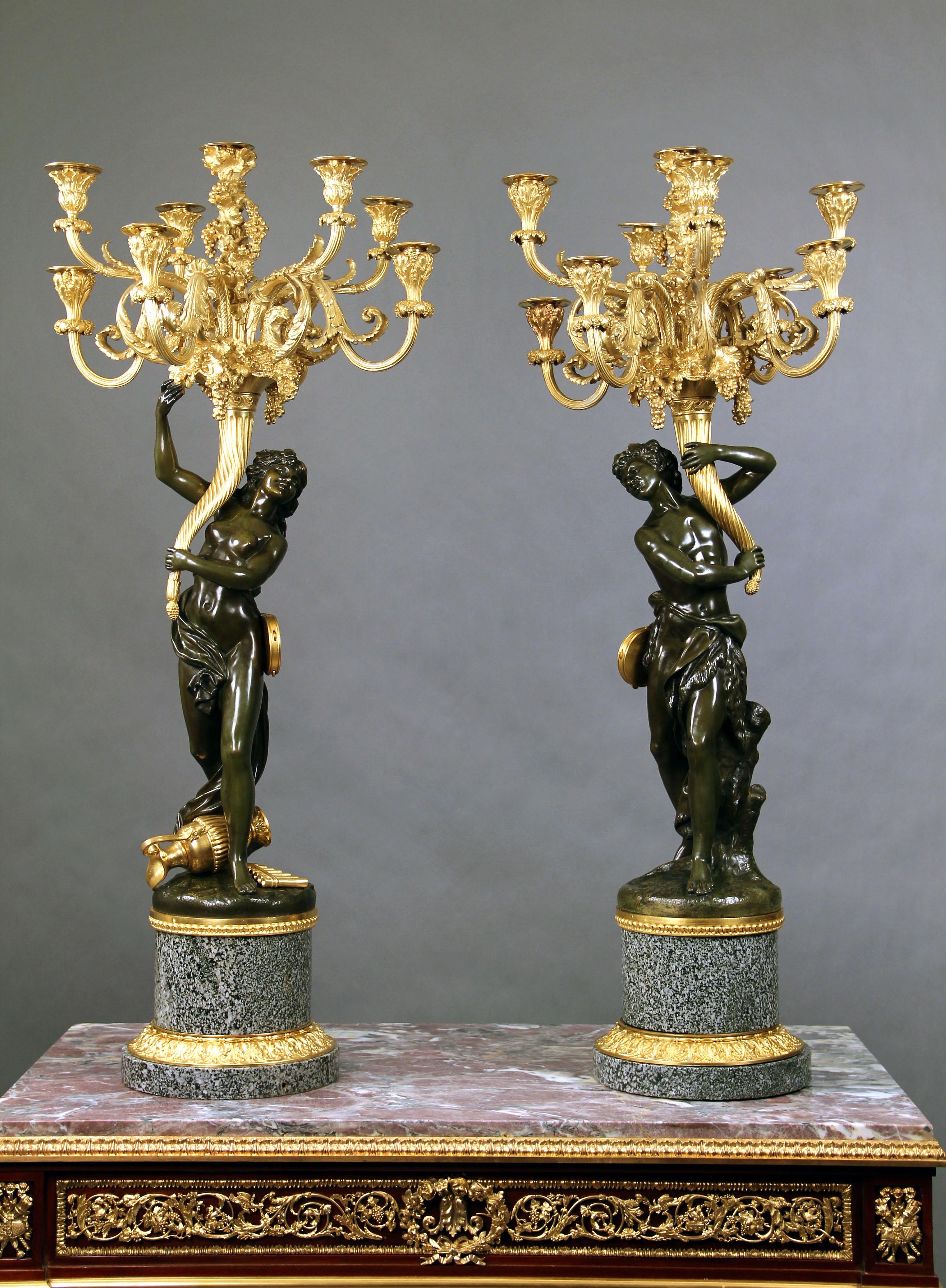 A wonderful pair of late 19th century two tone bronze nine-light candelabra.

After Clodion.

Each cast as a female and a male figure from a bacchanale upholding eight scroll branches with a central branch in the fotm of a quiver, on a
