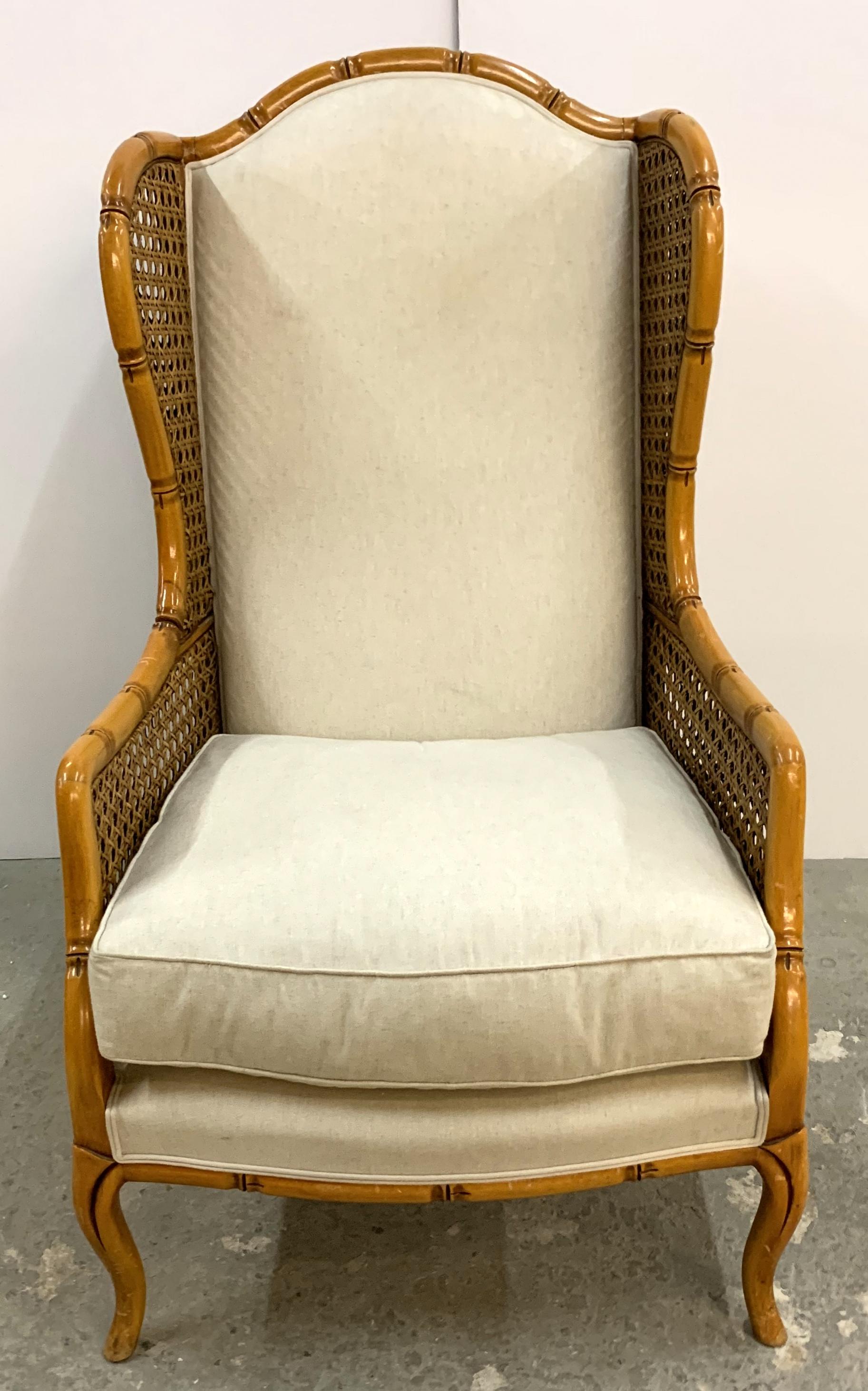 A wonderful pair of oversized rattan and bamboo carved wood english wing chairs with beige upholstery and loose seat cushion.
Purchased from Lorin Marsh.